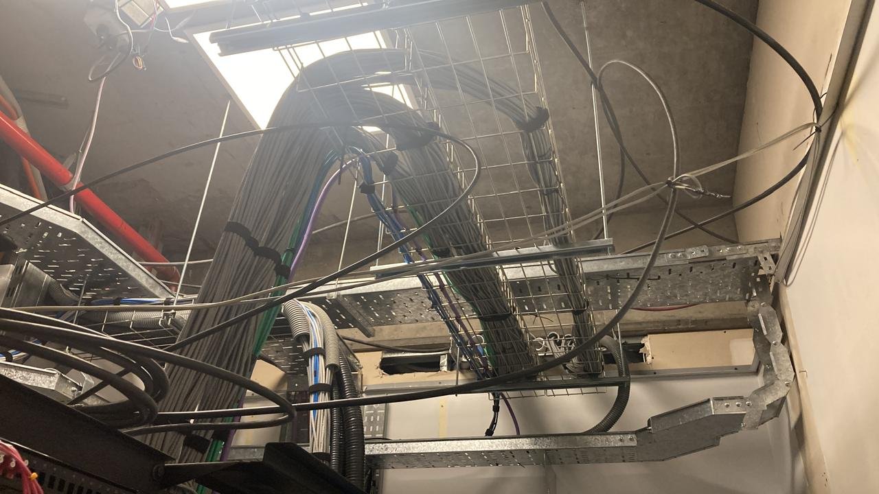 Aparato eléctrico con cables y componentes metálicos en una estructura de servidores o equipo de red.