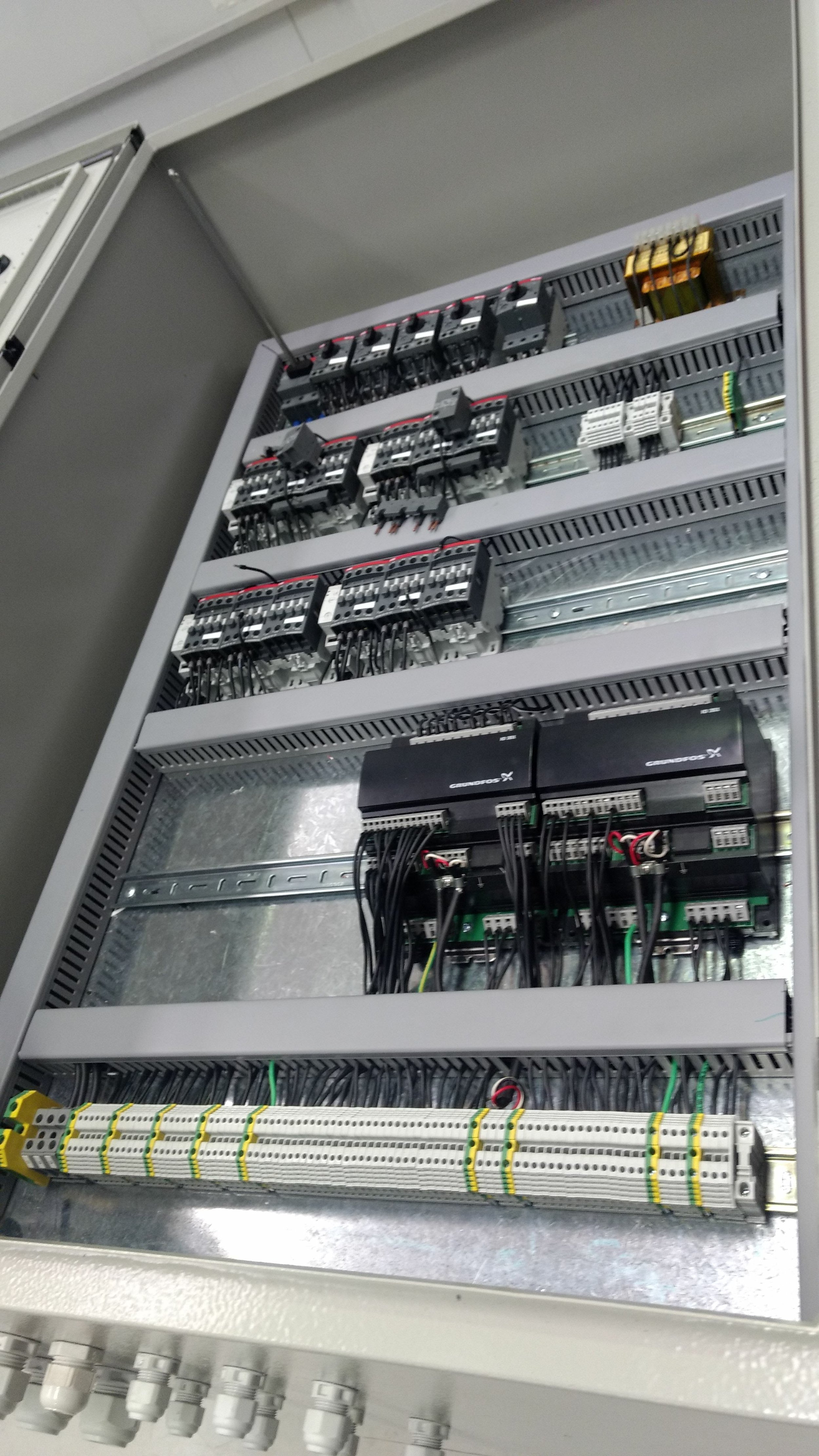 Panel de control eléctrico con componentes y cables.