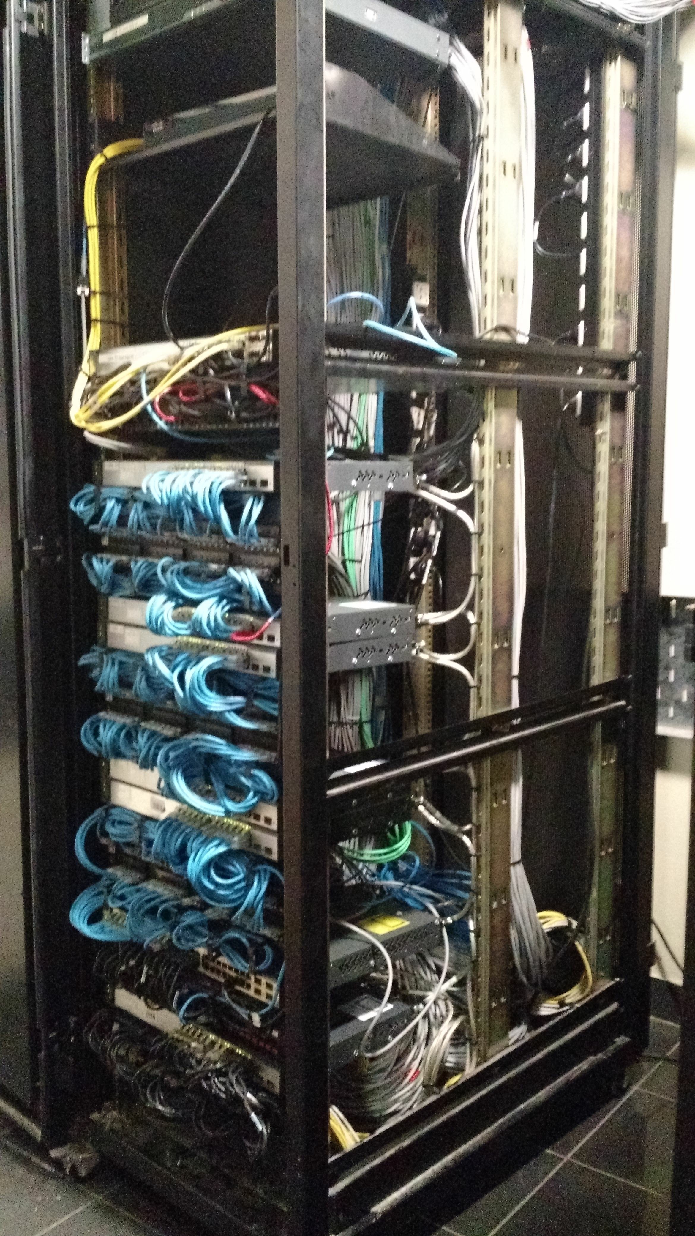 Gabinete de servidores con cables y componentes electrónicos en su interior.