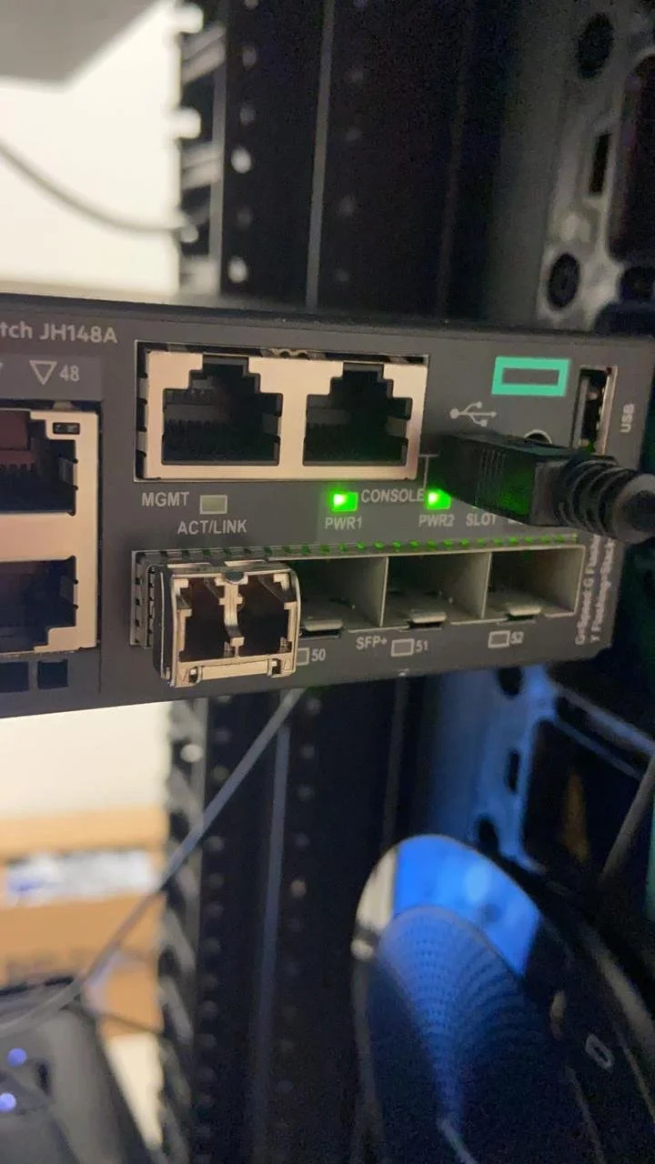 Módulo de red con puertos Ethernet, luces verdes indicadoras de estado y un cable conectado