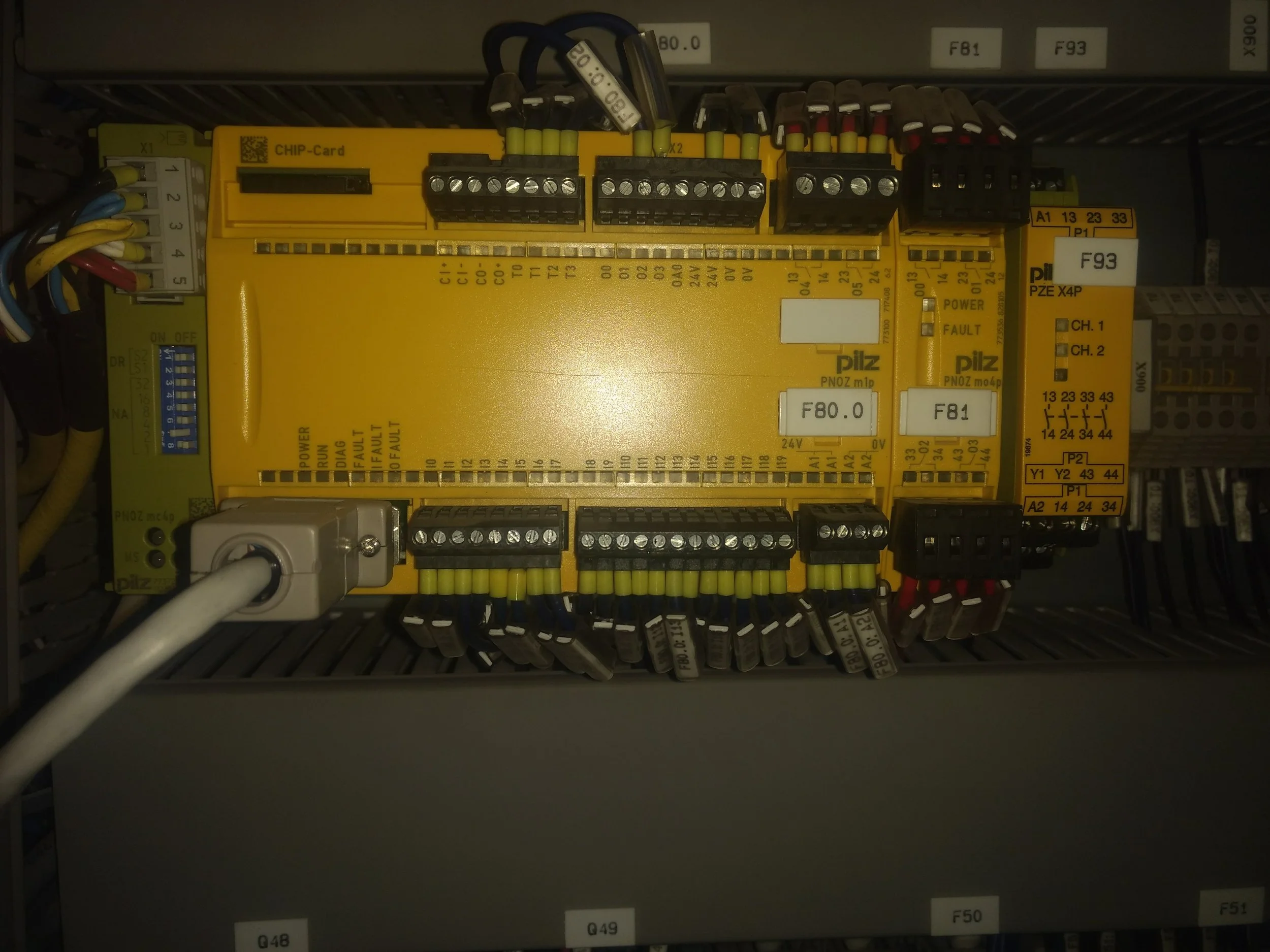 Cuadro de control eléctrico con cables y componentes electrónicos montados en una caja de panel.
