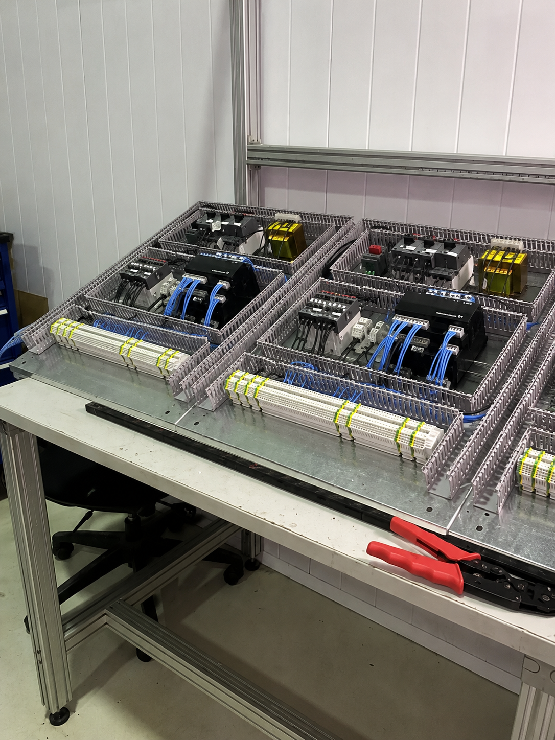 Tablero de control eléctrico con componentes y cables en un taller industrial