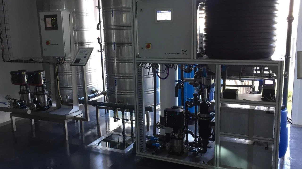 Sistema de filtración y tratamiento de agua industrial con tanques, tuberías y bombas.