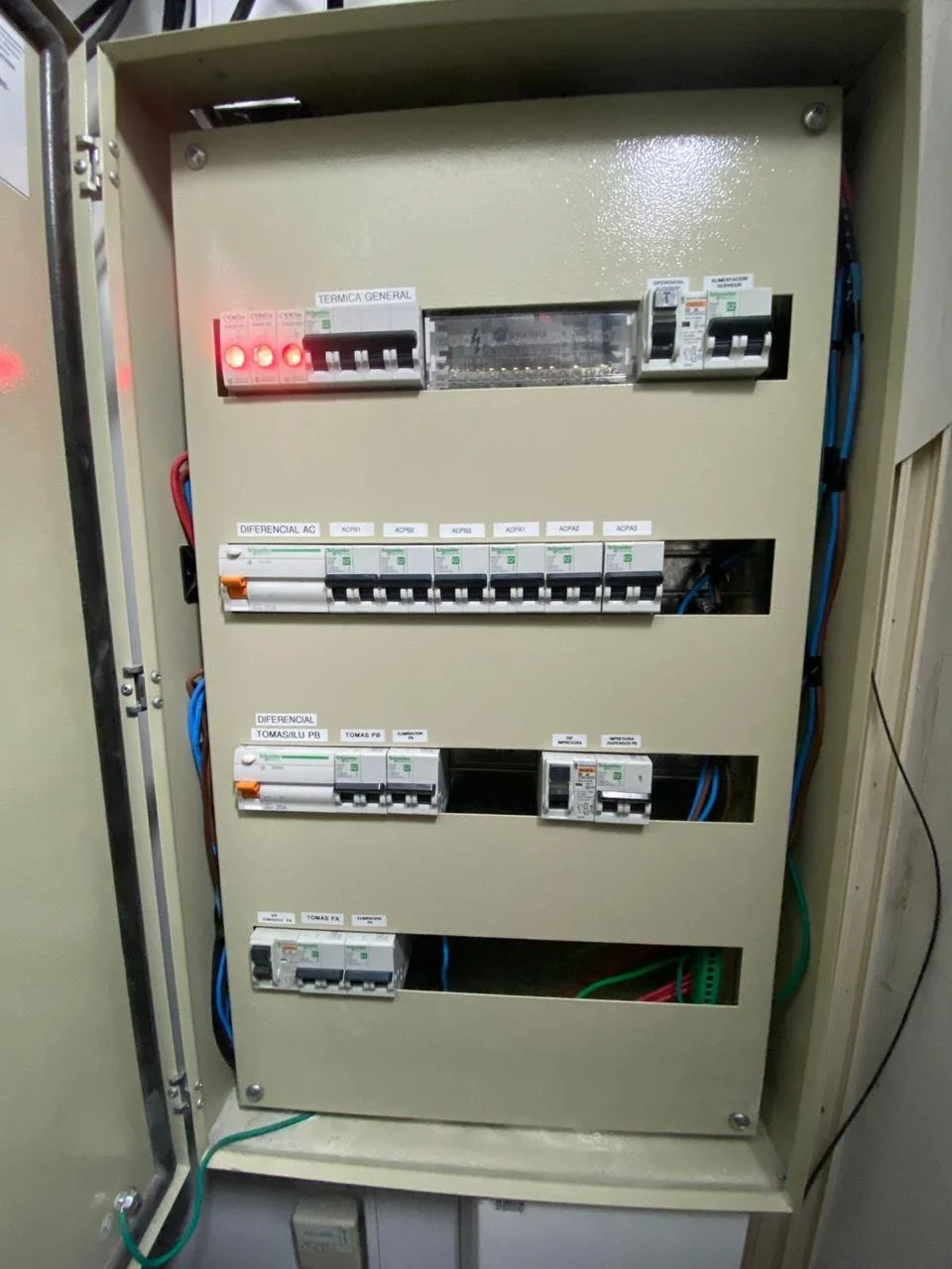Cuadro eléctrico con varios interruptores y componentes eléctricos, con cables conectados por dentro.