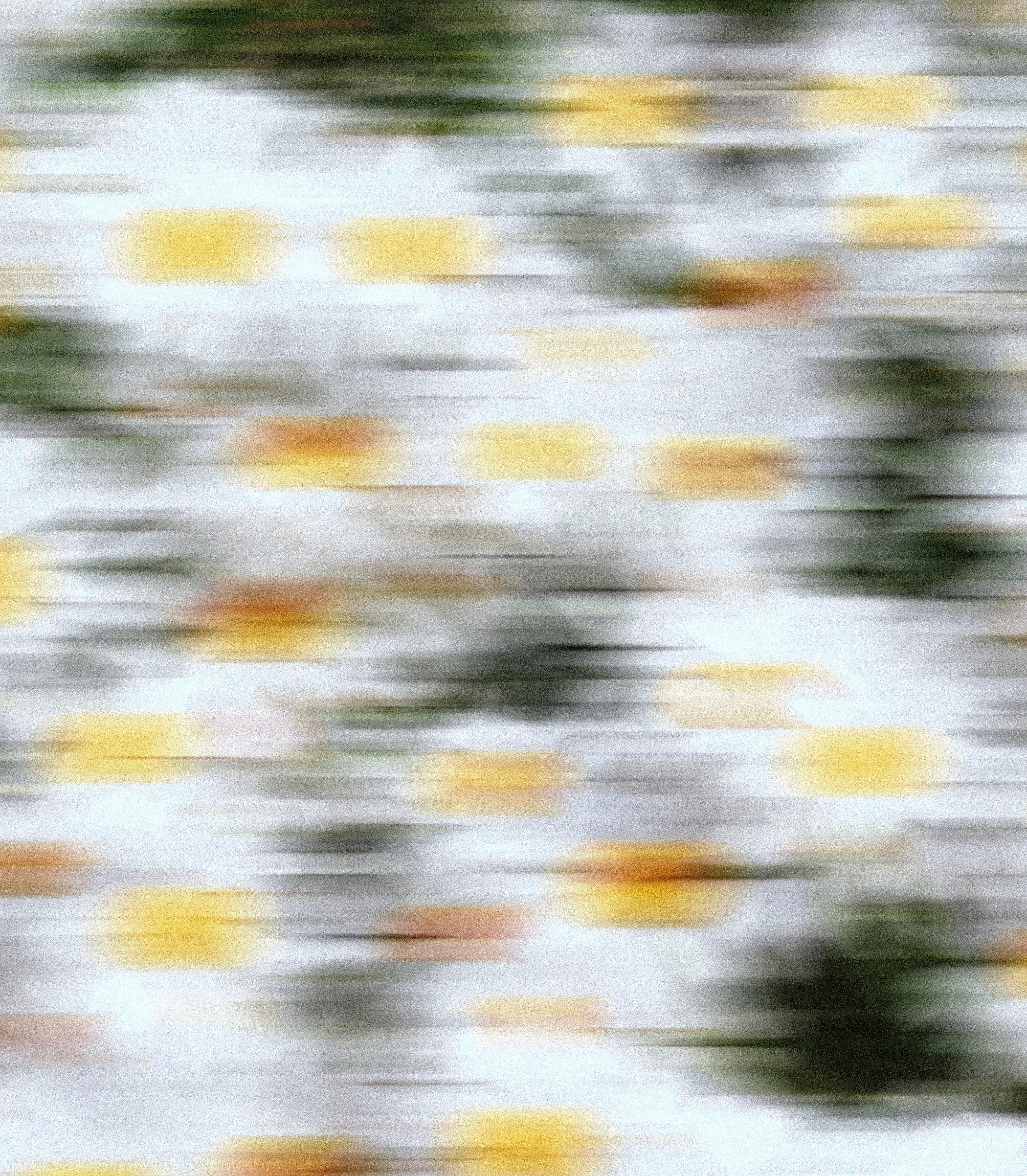 Image floue avec des taches de couleurs jaunes, vertes, orangées et blanches.