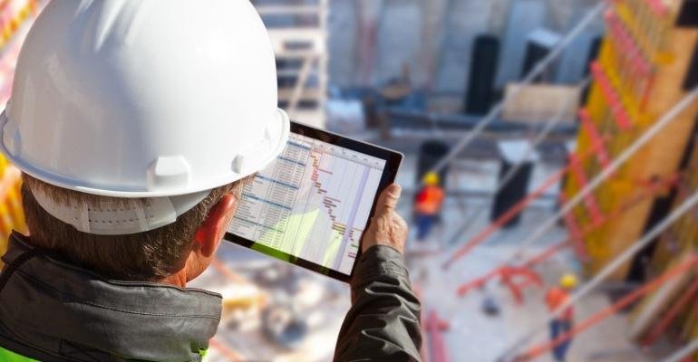 Construction professional reviewing project financial data on a jobsite