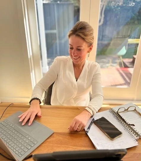 Founder Nicole Huntley working at a deskand smiling