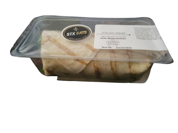 A clear plastic container with a black and white label from STX Eats, containing an Italian wrap that is cut into pieces.