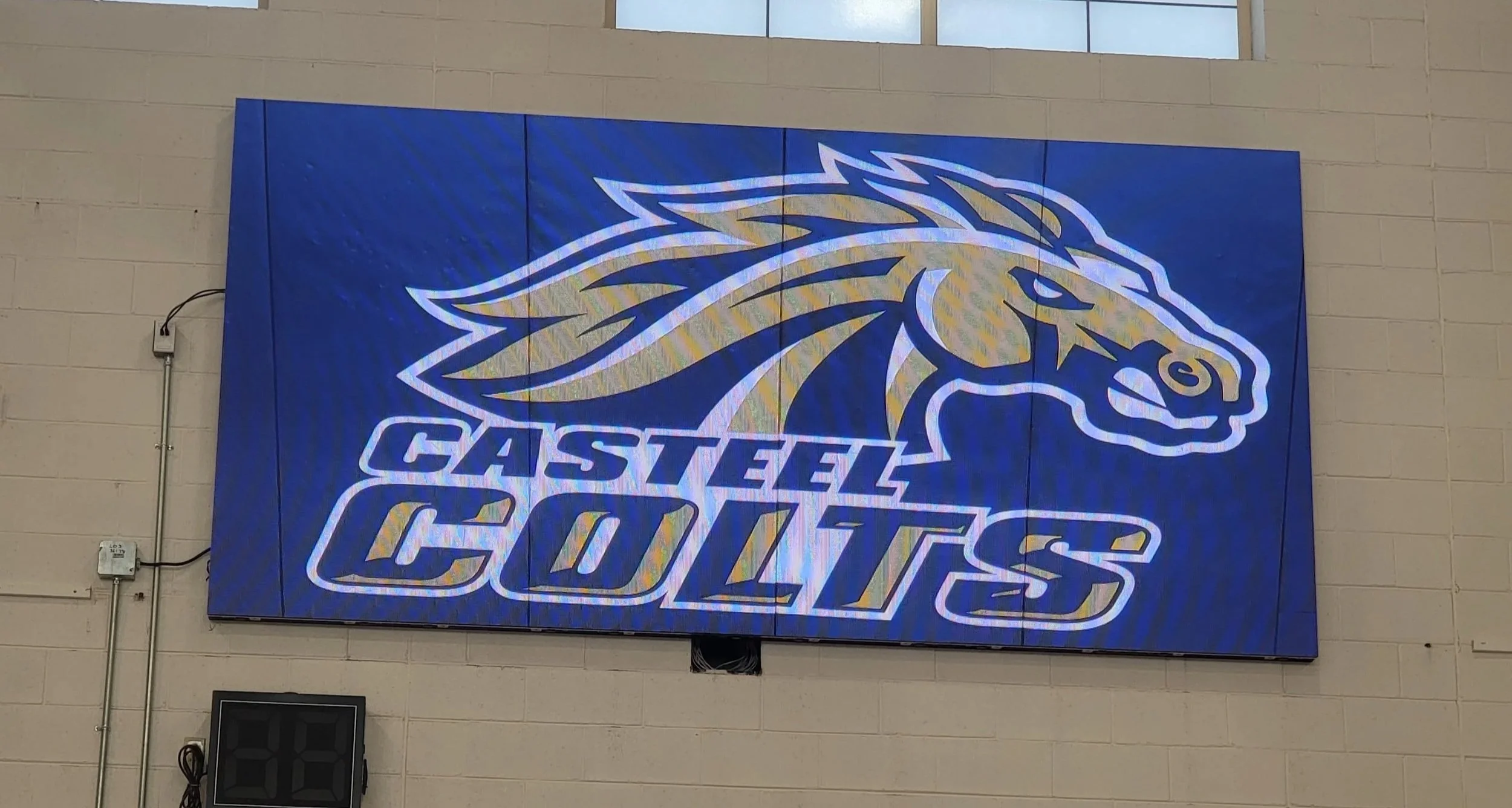 Large digital display with the Gasteel Coyotes logo, featuring a coyote head in profile on a blue background, and the words 'Gasteel Coyotes' underneath.