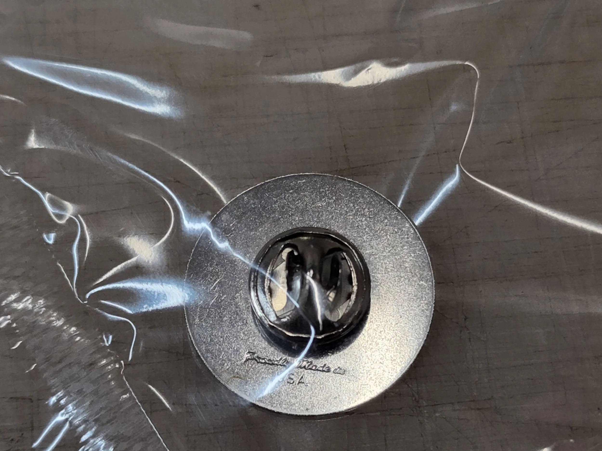 A close-up view of a stainless steel kitchen sink with a shiny surface and a metallic drain at the bottom center.