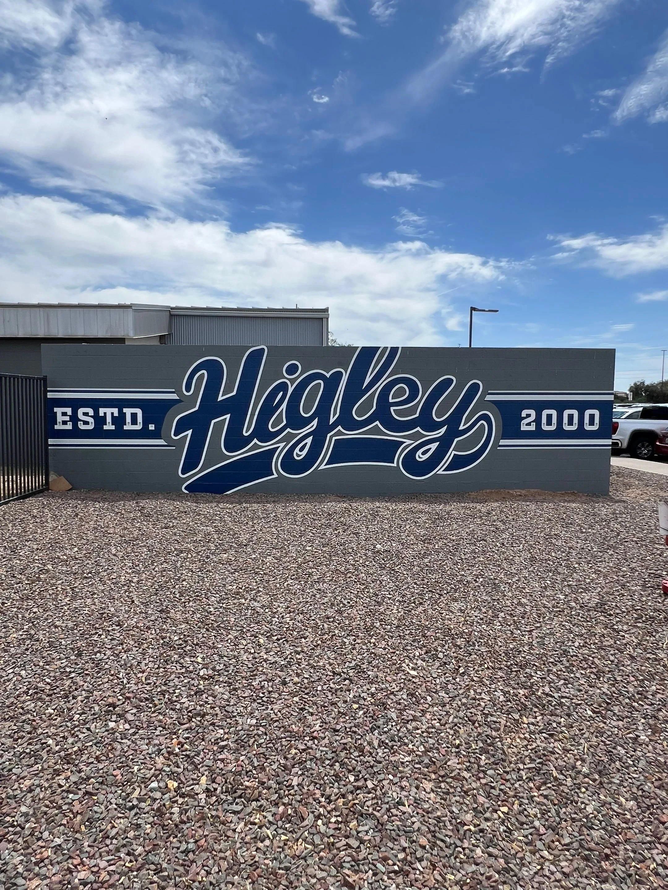 A sign with the word 'Hiley' written in large script, with 'ESTD. 2000' on the left and right sides of the sign, located outdoors under a partly cloudy sky.