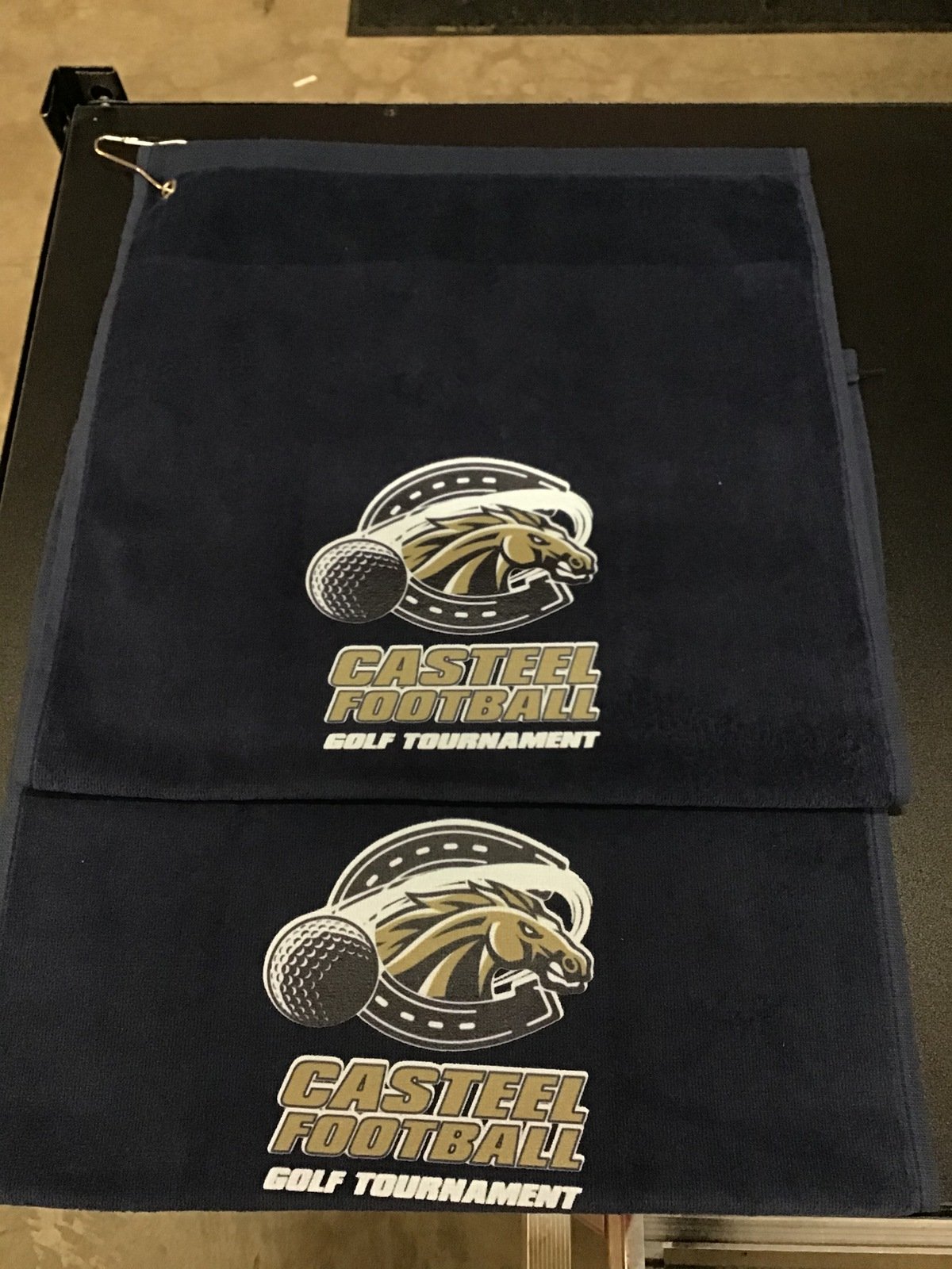 Black tote bags with a logo of a horse's head and a golf ball, and text that reads "CASTEEL FOOTBALL GOLF TOURNAMENT."