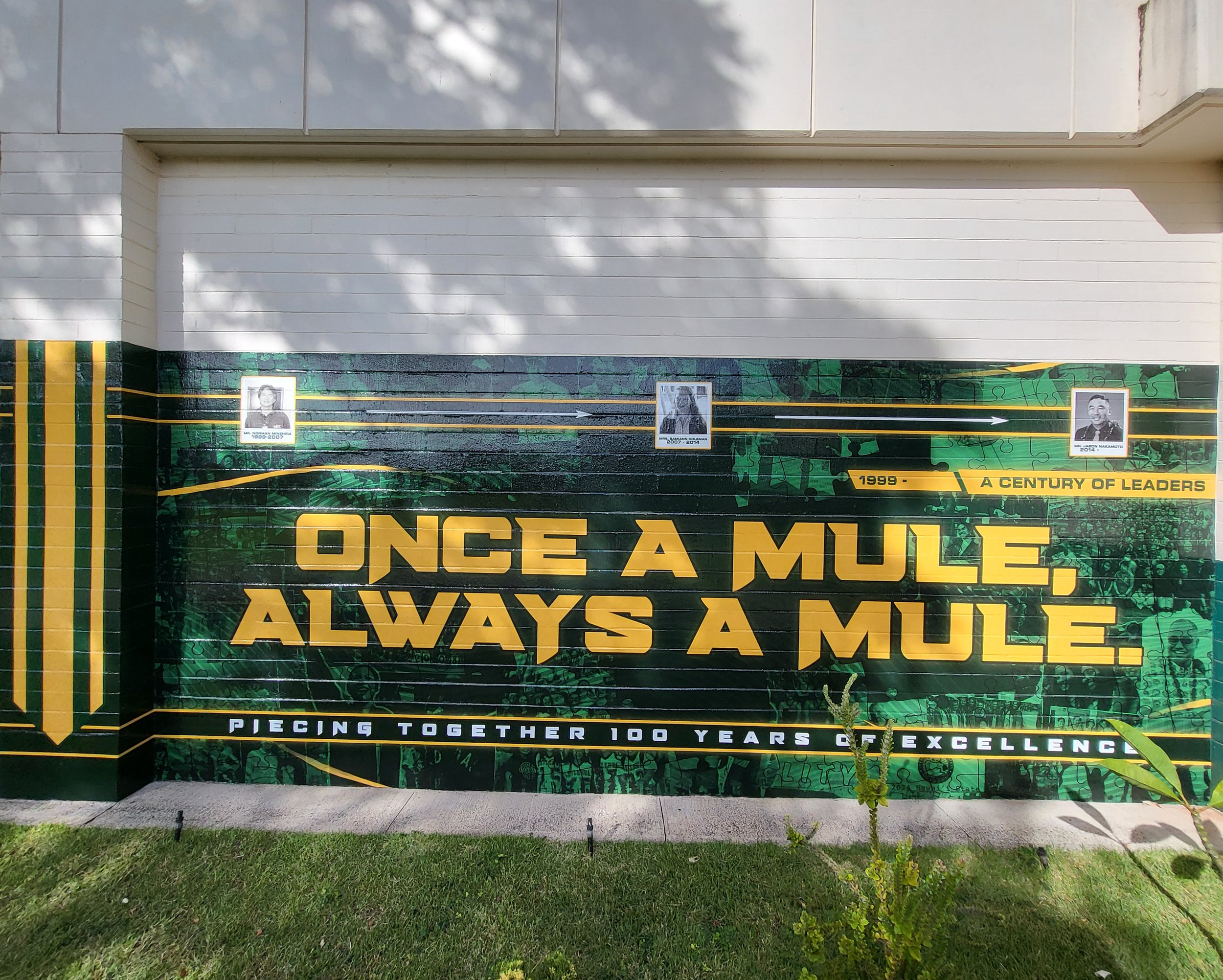 A mural featuring historical figures with a timeline and message 'Once a Mule, Always a Mule', celebrating 100 years of excellence.
