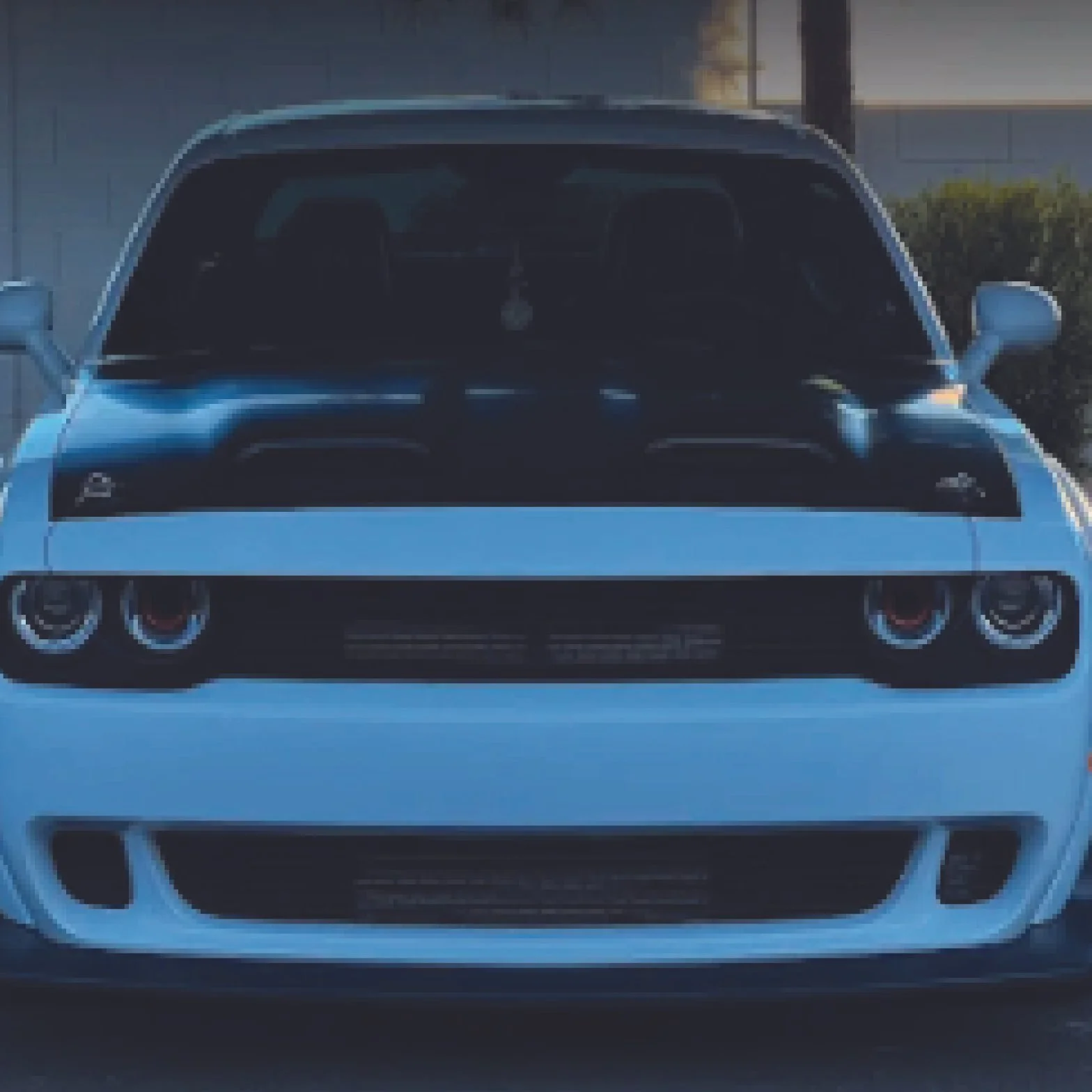 Front view of a light blue sports car with distinctive headlights and a black grille.