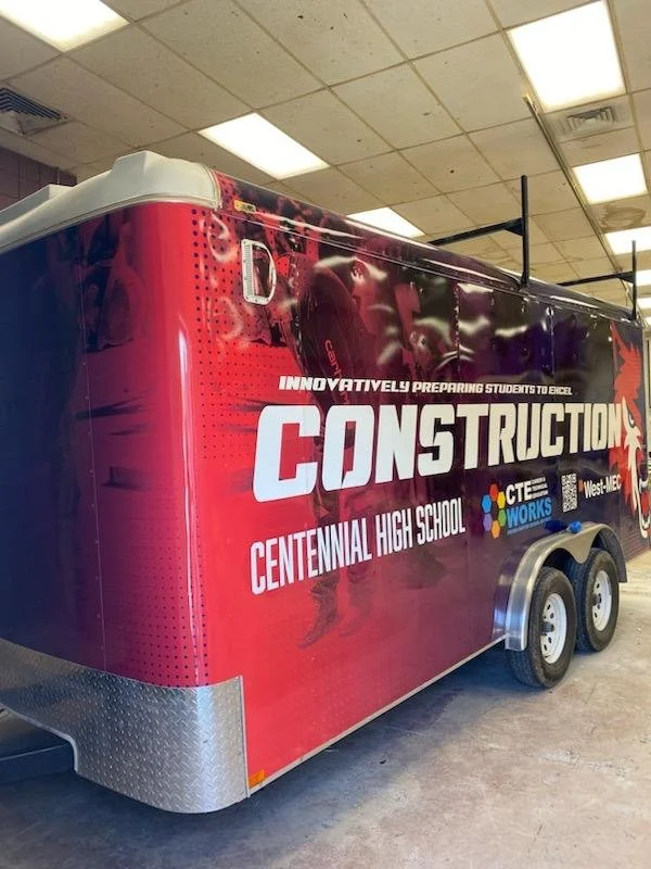 A trailer promoting Centennial High School's construction program, featuring a red and black design with the school name, slogan about preparing students to excel, and logos of CTE Works and West-MEC.