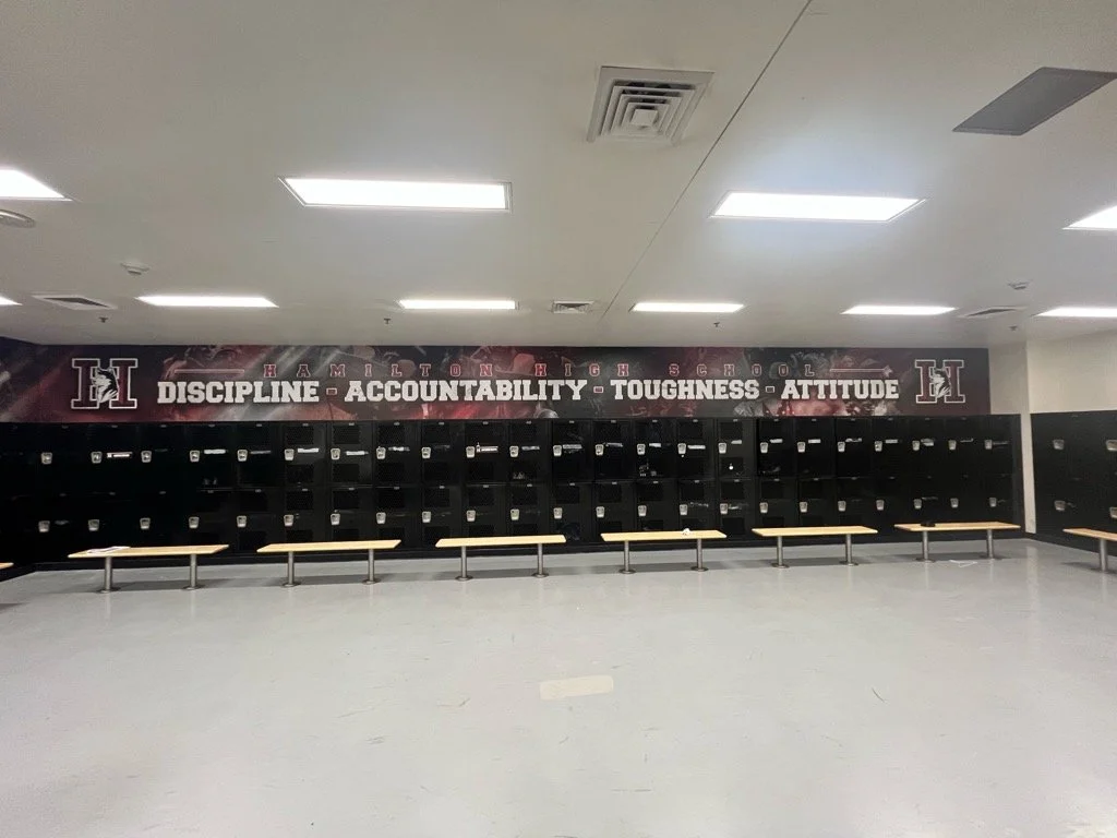 School lockers with a banner overhead displaying Hamilton High School and words: Discipline, Accountability, Toughness, Attitude.