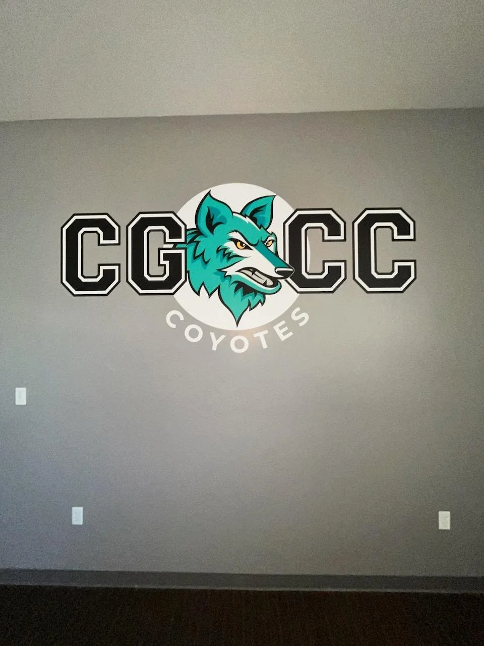 Wall decal with a stylized wolf logo, the letters 'CGCCC' around it, and the word 'Coyotes' below.