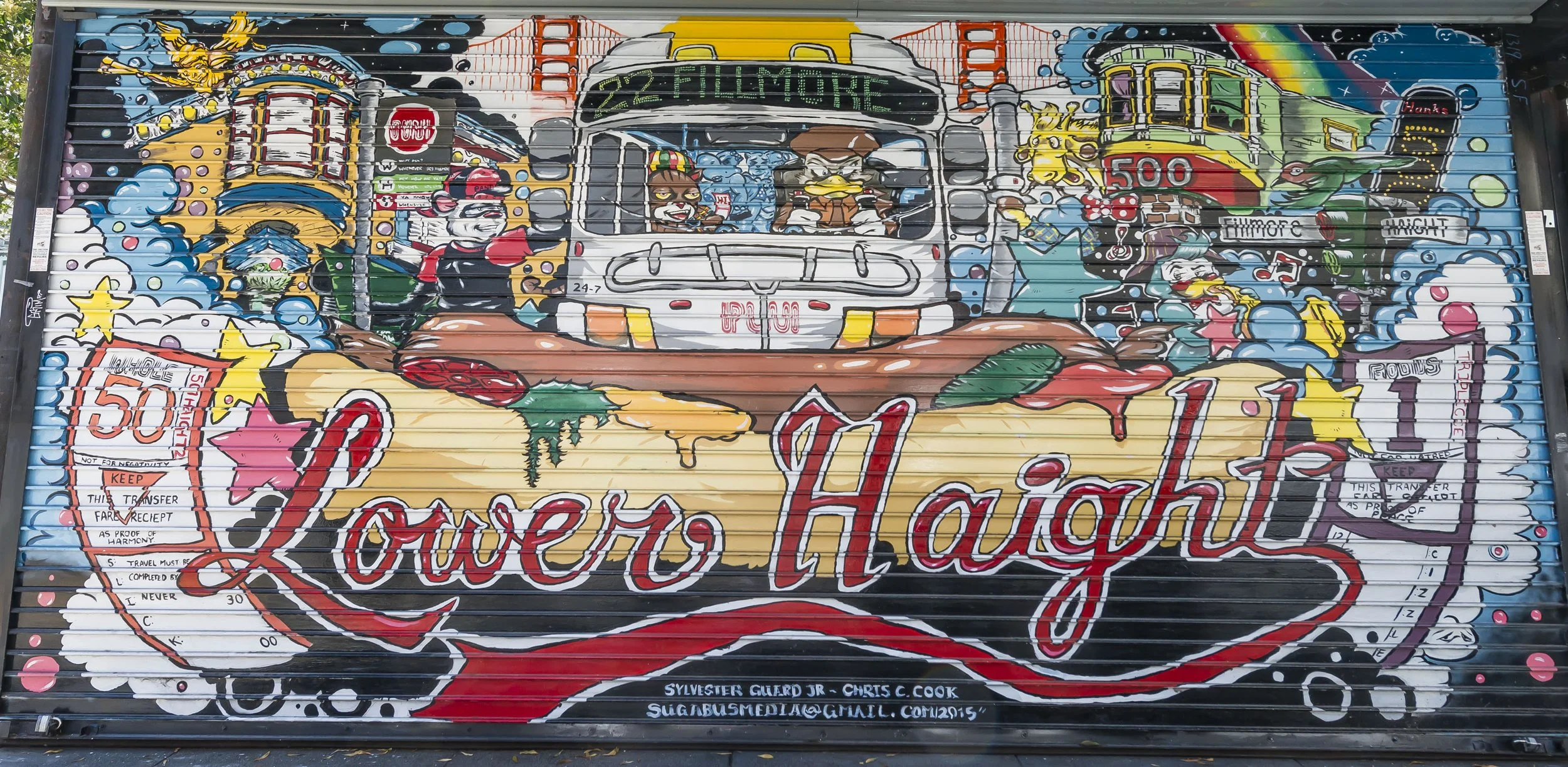 Colorful graffiti mural featuring a bus, characters, text, and various symbols, with prominent words like 'Love' and 'Haitian' and festive imagery such as stars and rainbows.