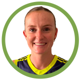 A woman smiling with a close-cropped haircut, wearing a sports jersey in front of a green circular background.