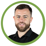 A man with a beard and short brown hair, wearing a black shirt, smiling against a white background with a green circular border.