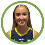 A young woman with blond hair smiling, wearing a sports jersey with a blue and yellow collar, in a circular frame with a green outline.