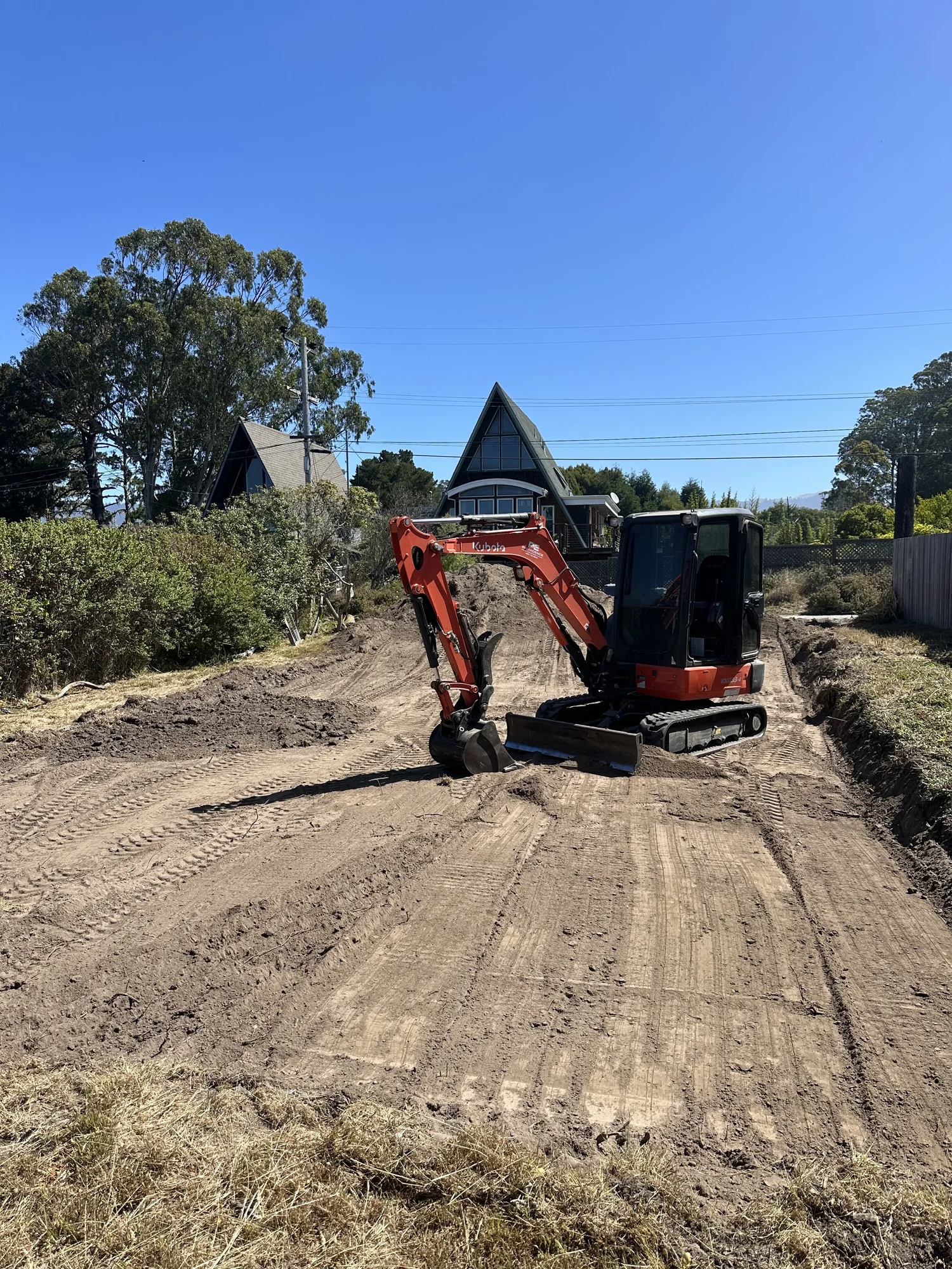 Mini excavator grading and preparing a site
