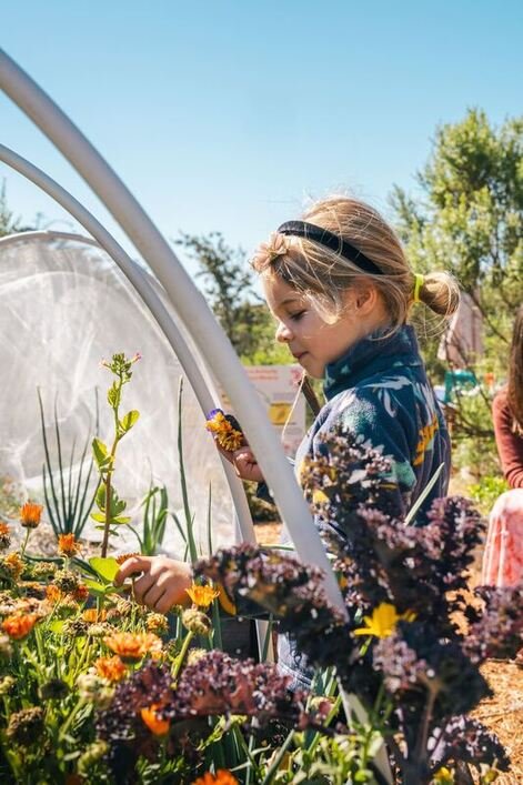 Child in the garden at the Play Grove at One Cool Earth.