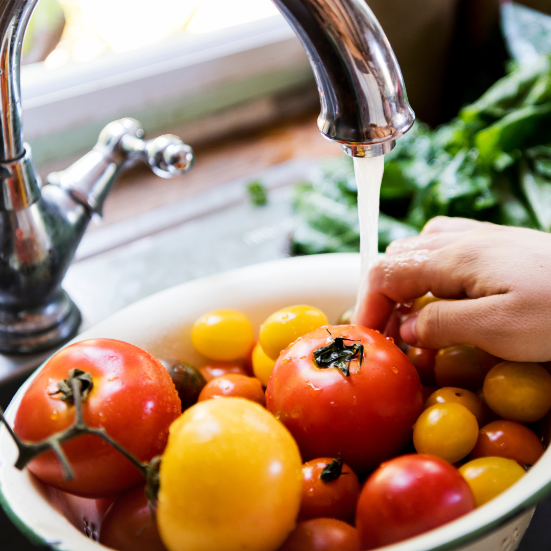 Bowl of tomatoes and running water.