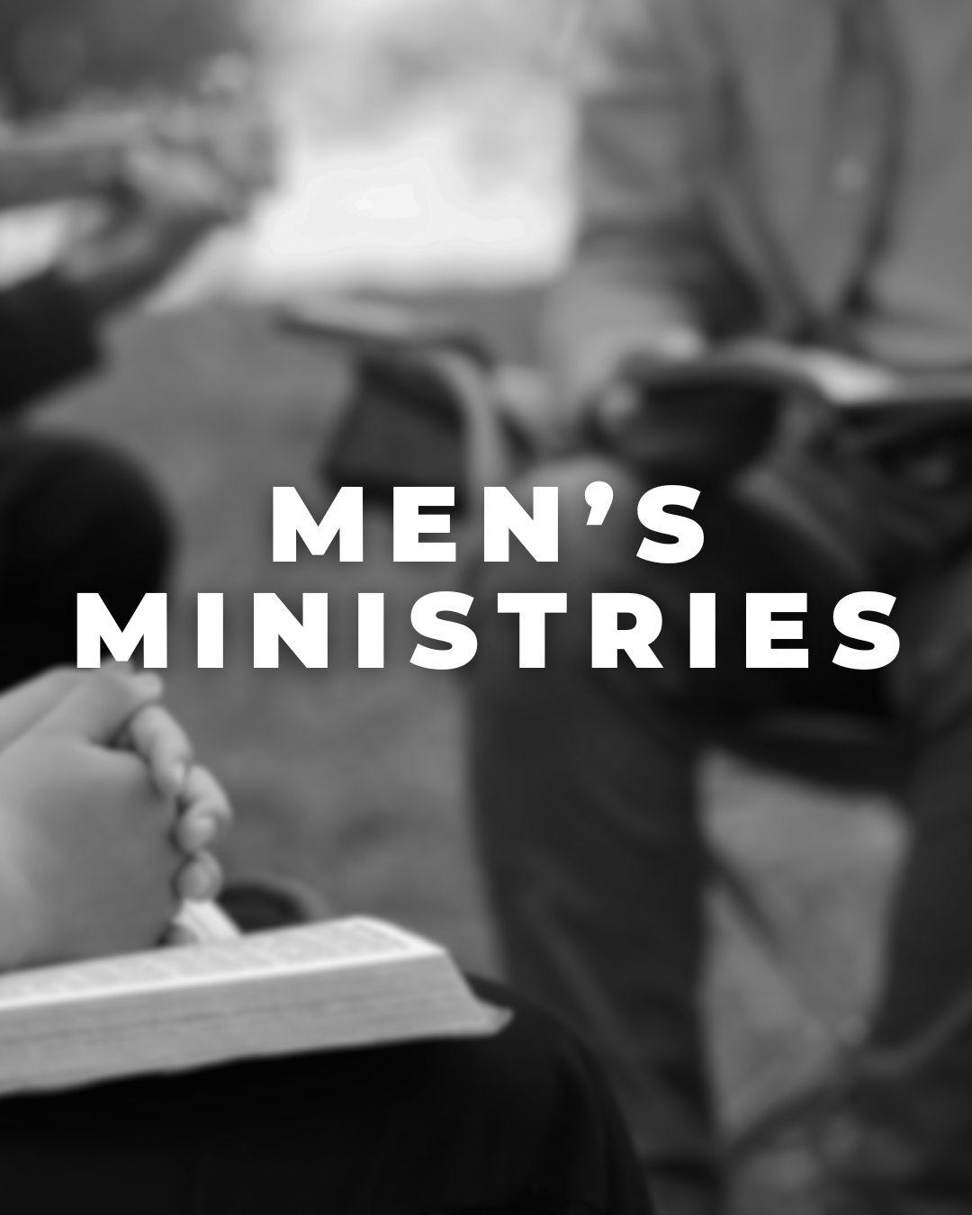 A person holding a book and praying, with another person standing nearby in a church or gathering space. The text overlay reads 'Men's Ministries'.