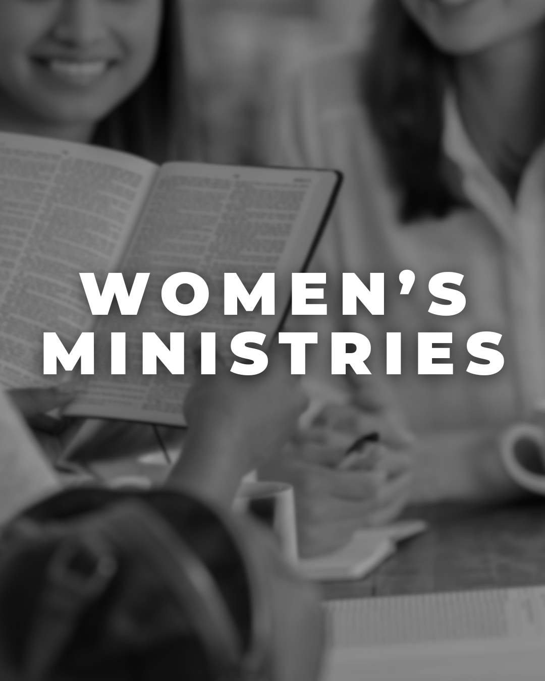 Women engaging in a discussion, with one holding a Bible, representing women's ministries.