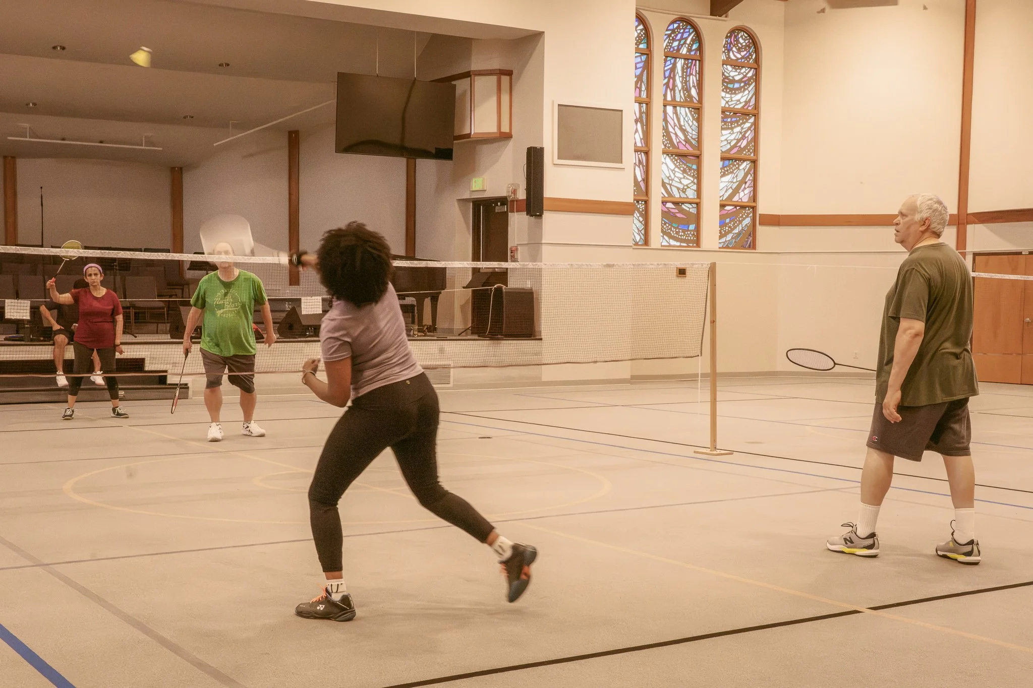 Community playing badminton in teams of 2