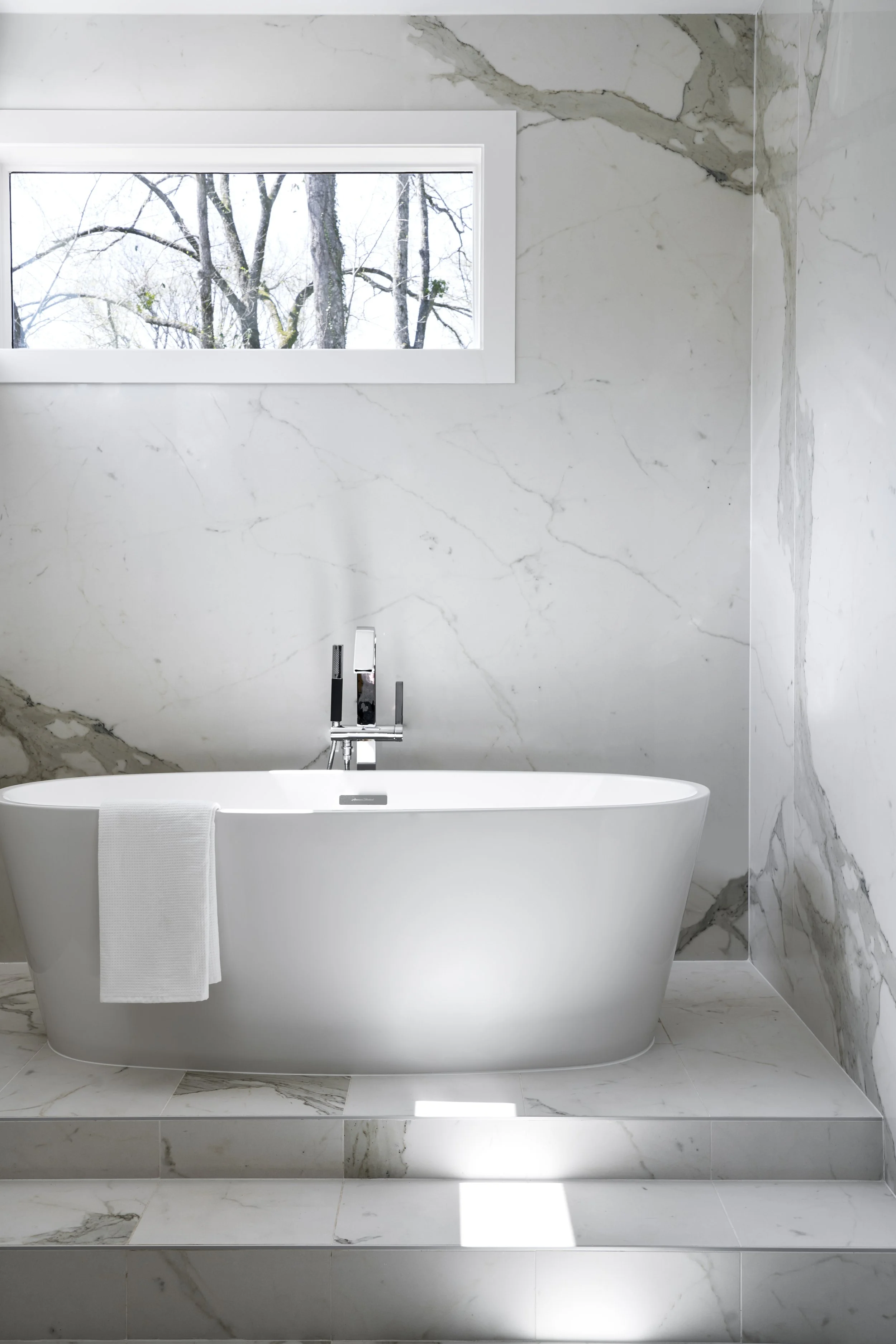 tub, freestanding tub, kohler, tub faucet, stone, marble, steps, window