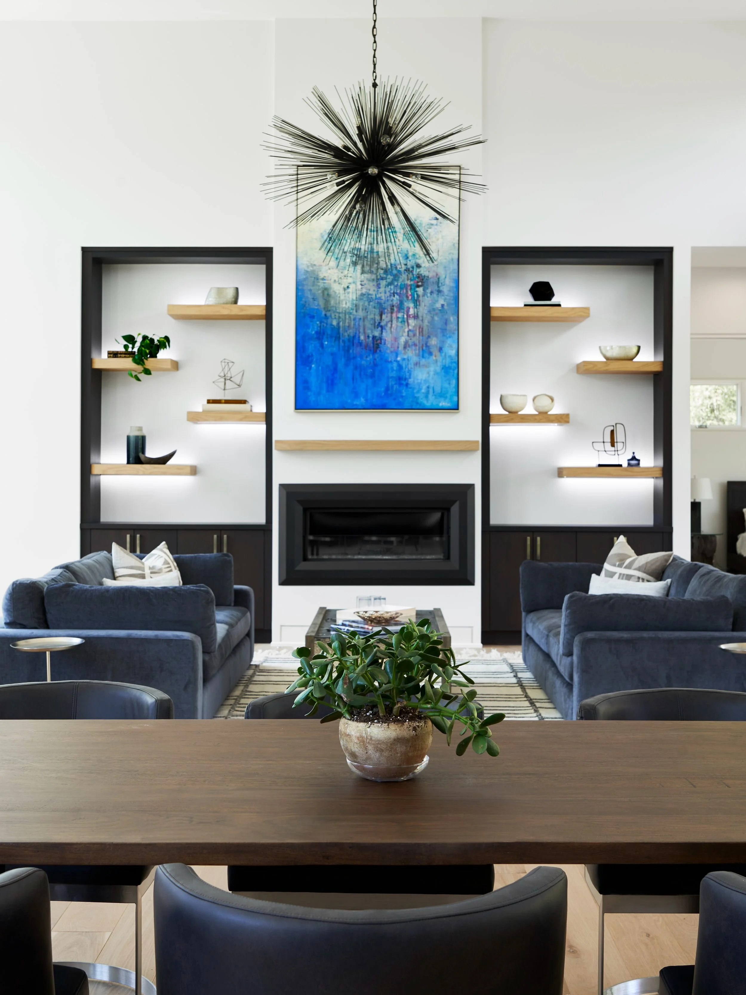 fireplace, chandelier, sofa, dining table, pillow shelves, dining chairs, dining room, living room