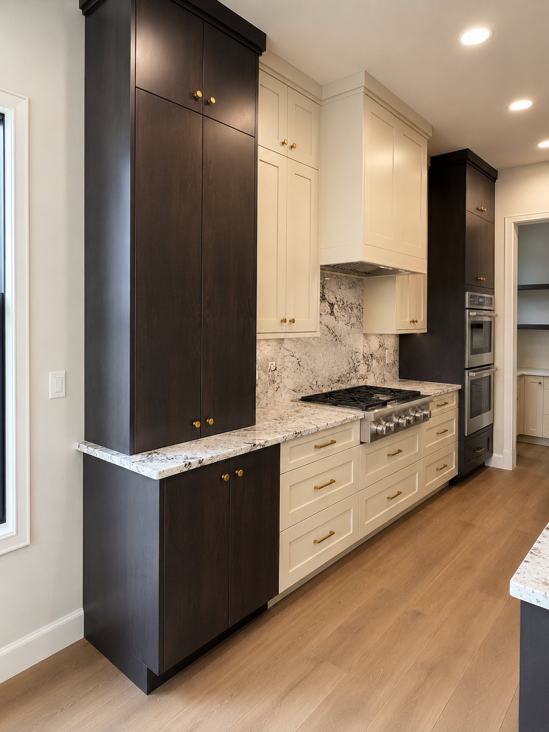 Kitchen with dark and white cabinets, marble countertops, a built-in stove, and oven