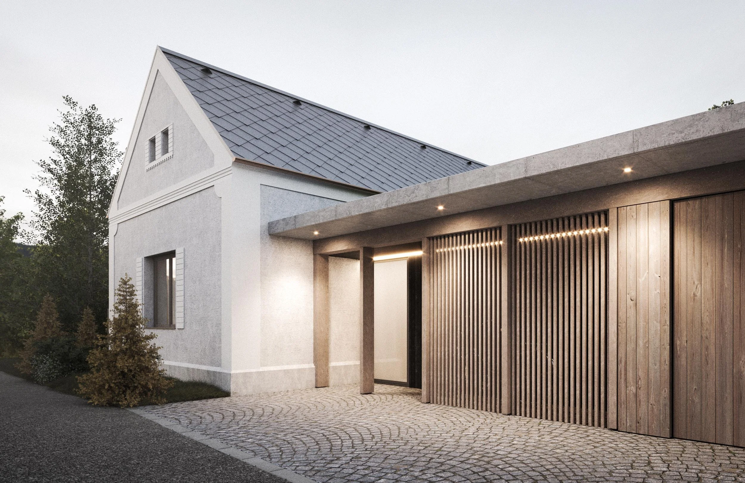 Exterior of a modern house at dusk with a white facade, a sloped gray roof, and a wooden slatted garage door. There are small trees and bushes along the sidewalk, and outdoor lighting under the concrete overhang.