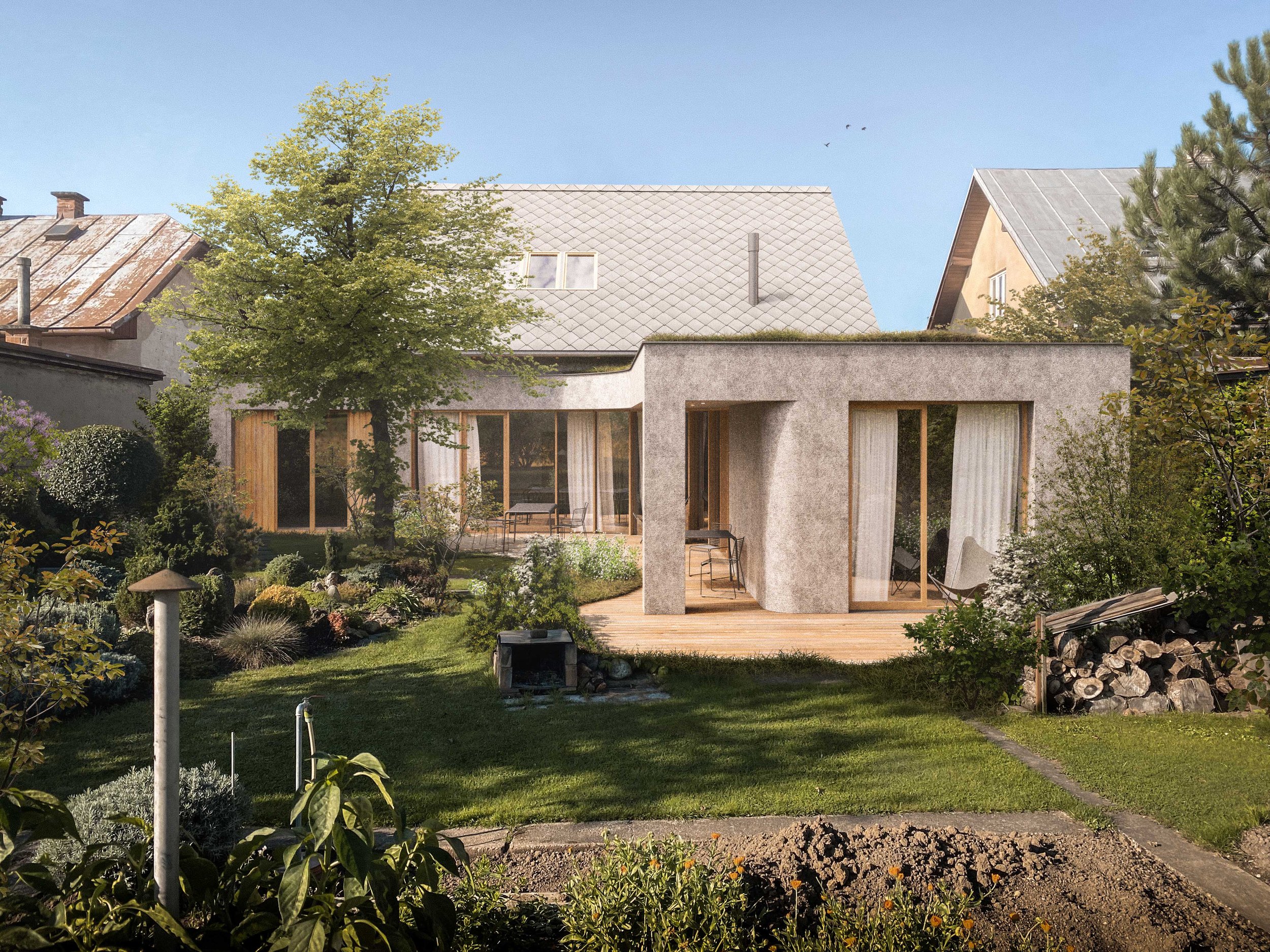 A backyard garden with lush green grass, various bushes and flowers, and a large tree on the left. There is a patio with outdoor chairs and a table, a stone walkway, and a modern house with large glass doors and a flat roof in the background. The sky is clear and blue.