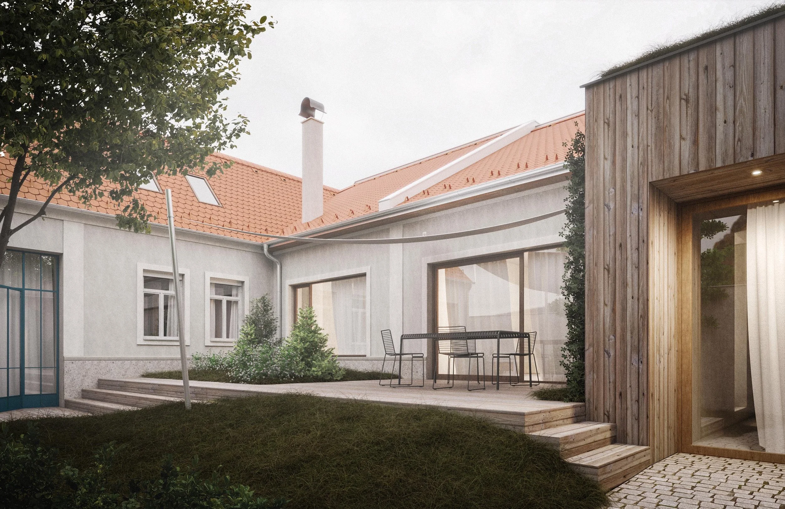 A backyard patio area with outdoor furniture, a wooden privacy wall, plants, a tree, and the exterior of a house with a red-tiled roof and skylights.