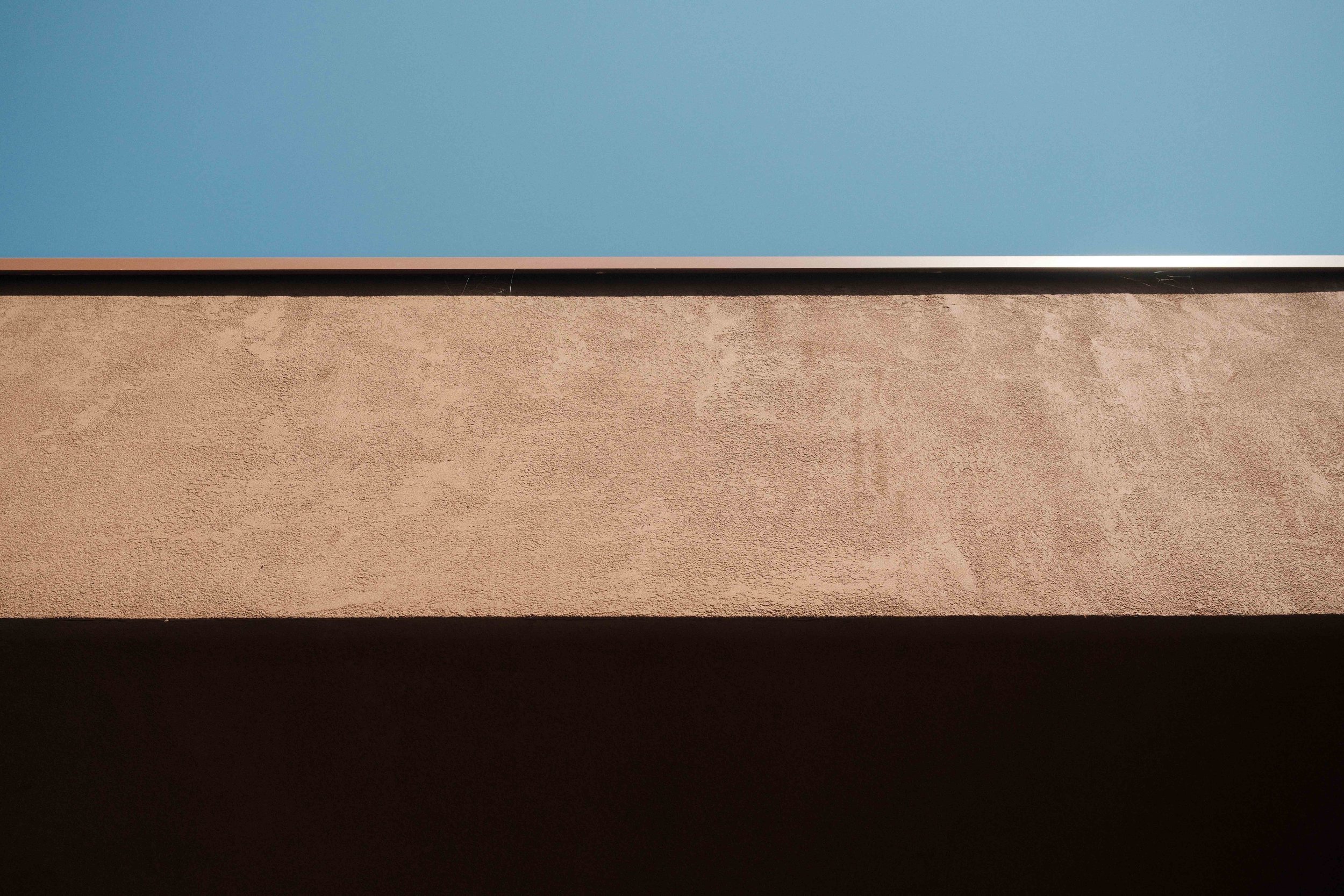 Close-up of a surface with distinct horizontal layers in shades of blue, beige, and black.