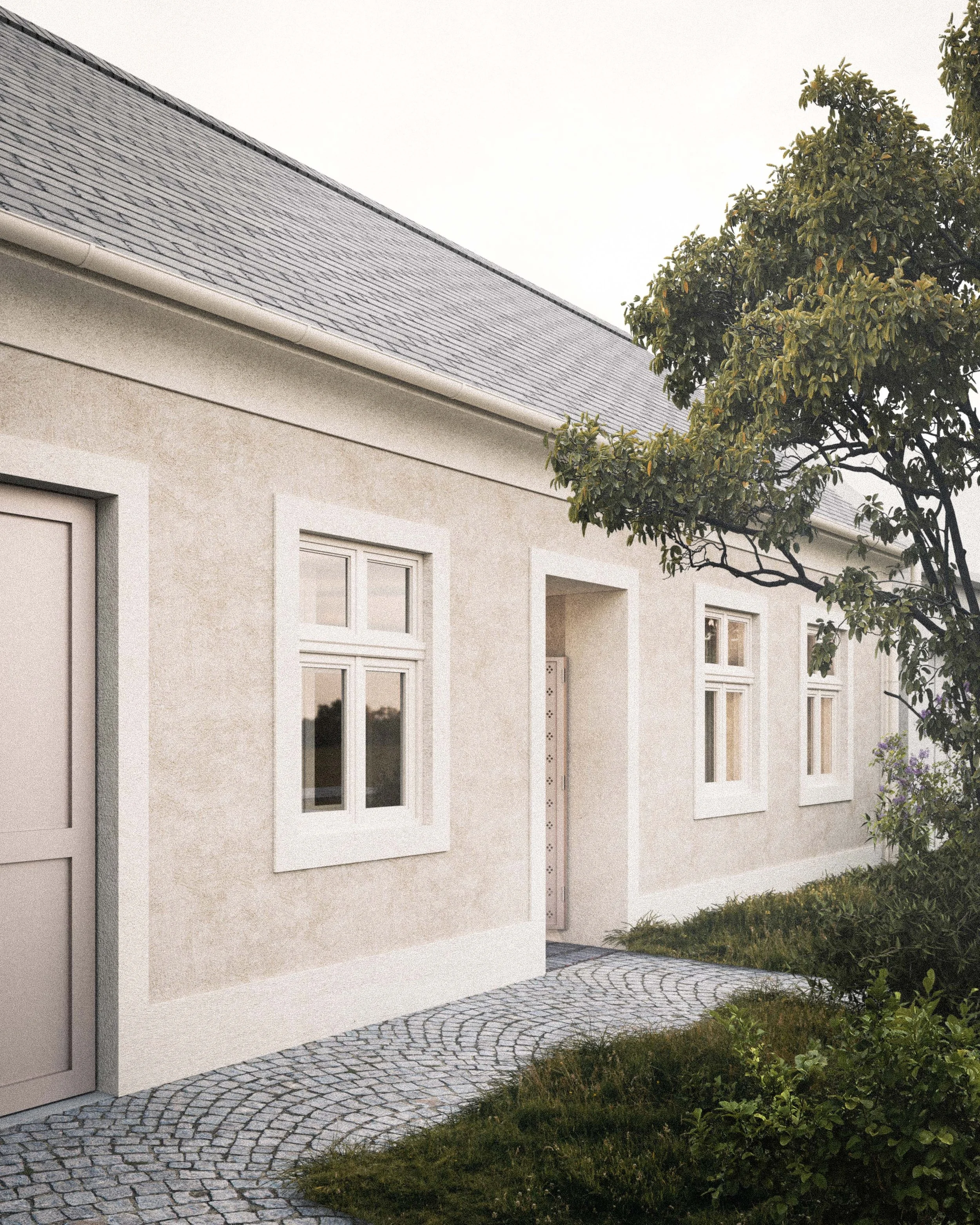 The side of a beige house with three windows, a sloped roof with gray shingles, and a garden area with bushes and a stone path.