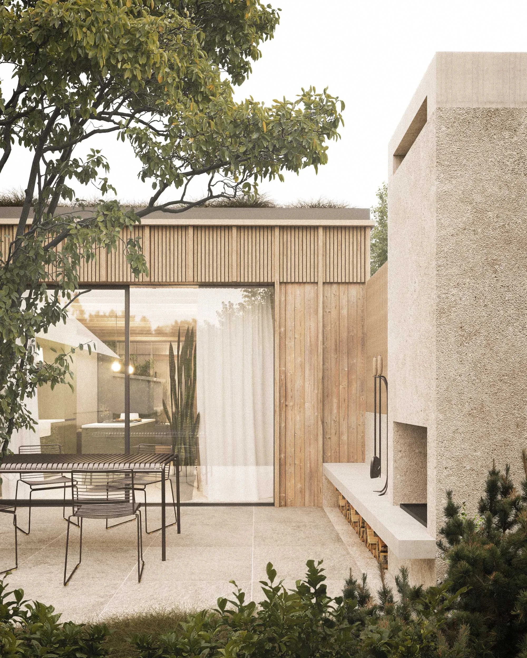 Modern house with a concrete stucco exterior, wood panel accents, large glass windows, an outdoor patio area with metal chairs, and surrounding greenery including trees and shrubs.