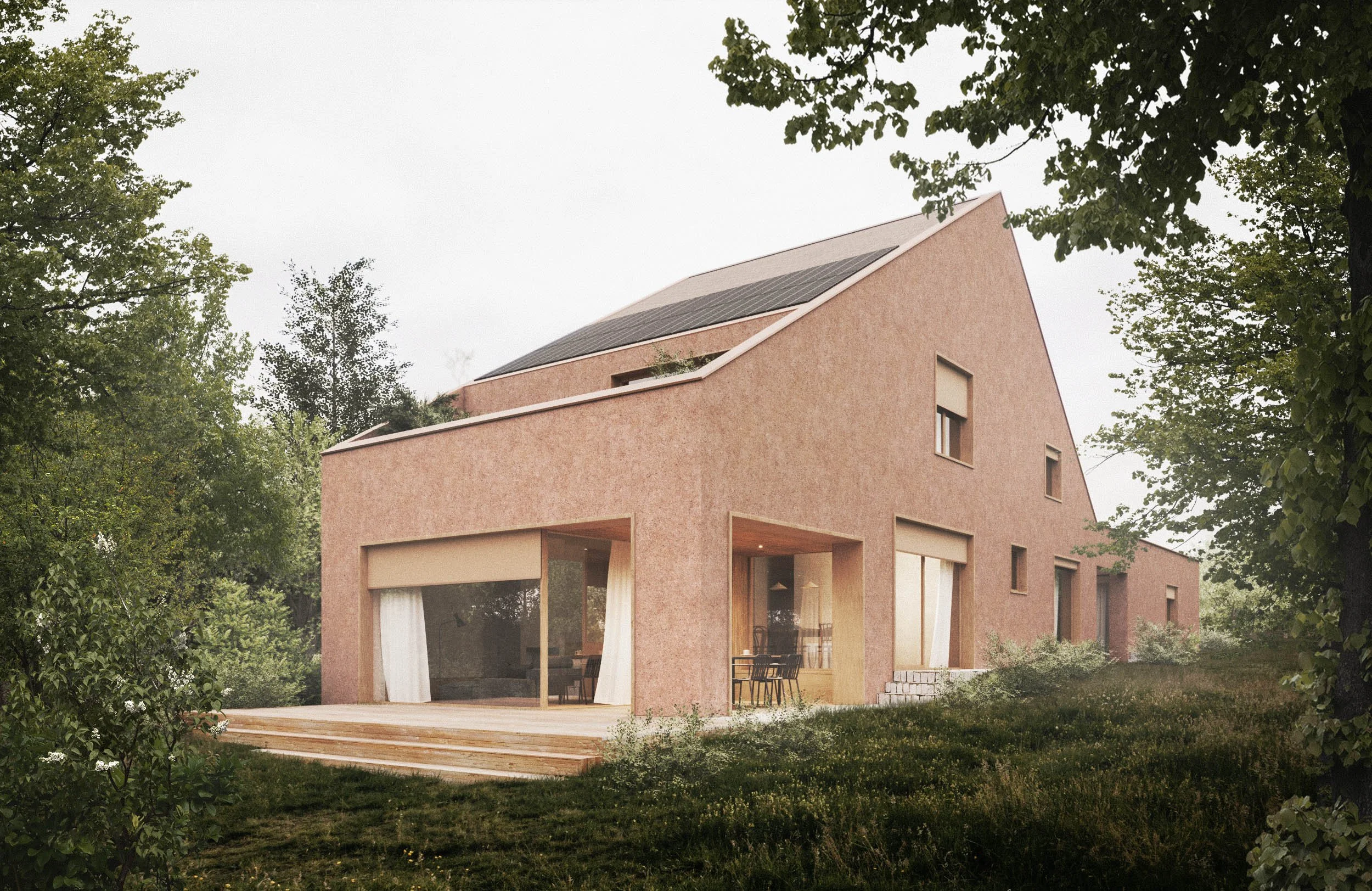 A modern house with a pinkish exterior, large windows, and a deck, surrounded by green trees and foliage.