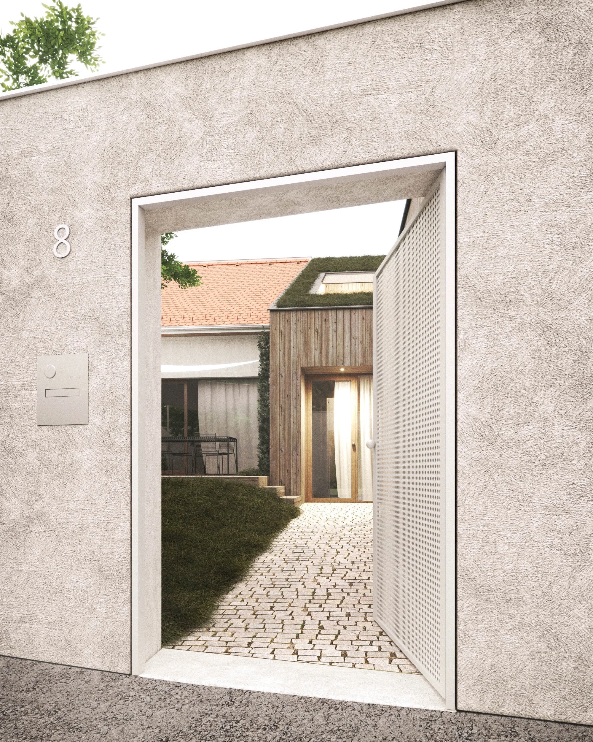 View through a large, open doorway with a textured white wall, showing a cobblestone pathway leading to a modern wooden building with a green roof, surrounded by grass and small trees.