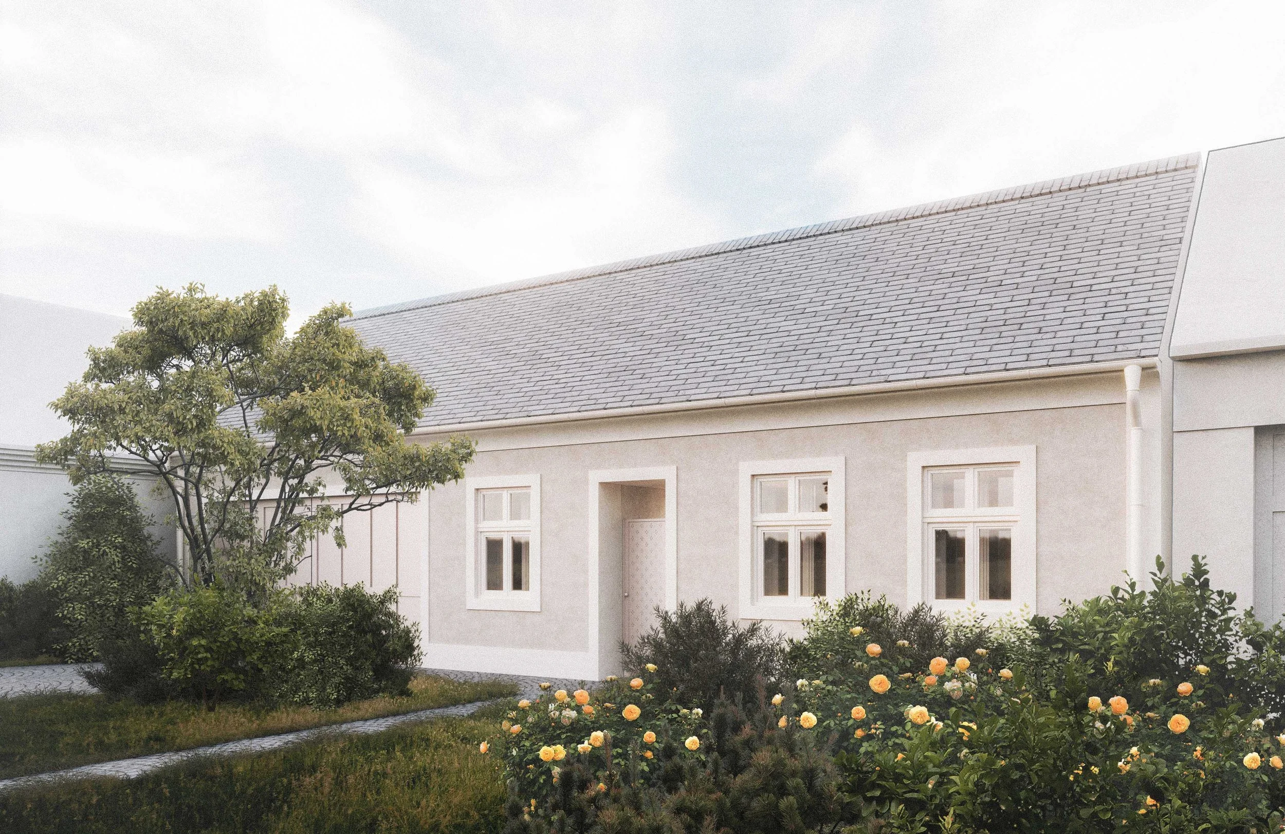 A house with beige exterior walls and white window frames, surrounded by a garden with green bushes, orange roses, and a tree. The roof is gray with shingles, and the sky is cloudy.