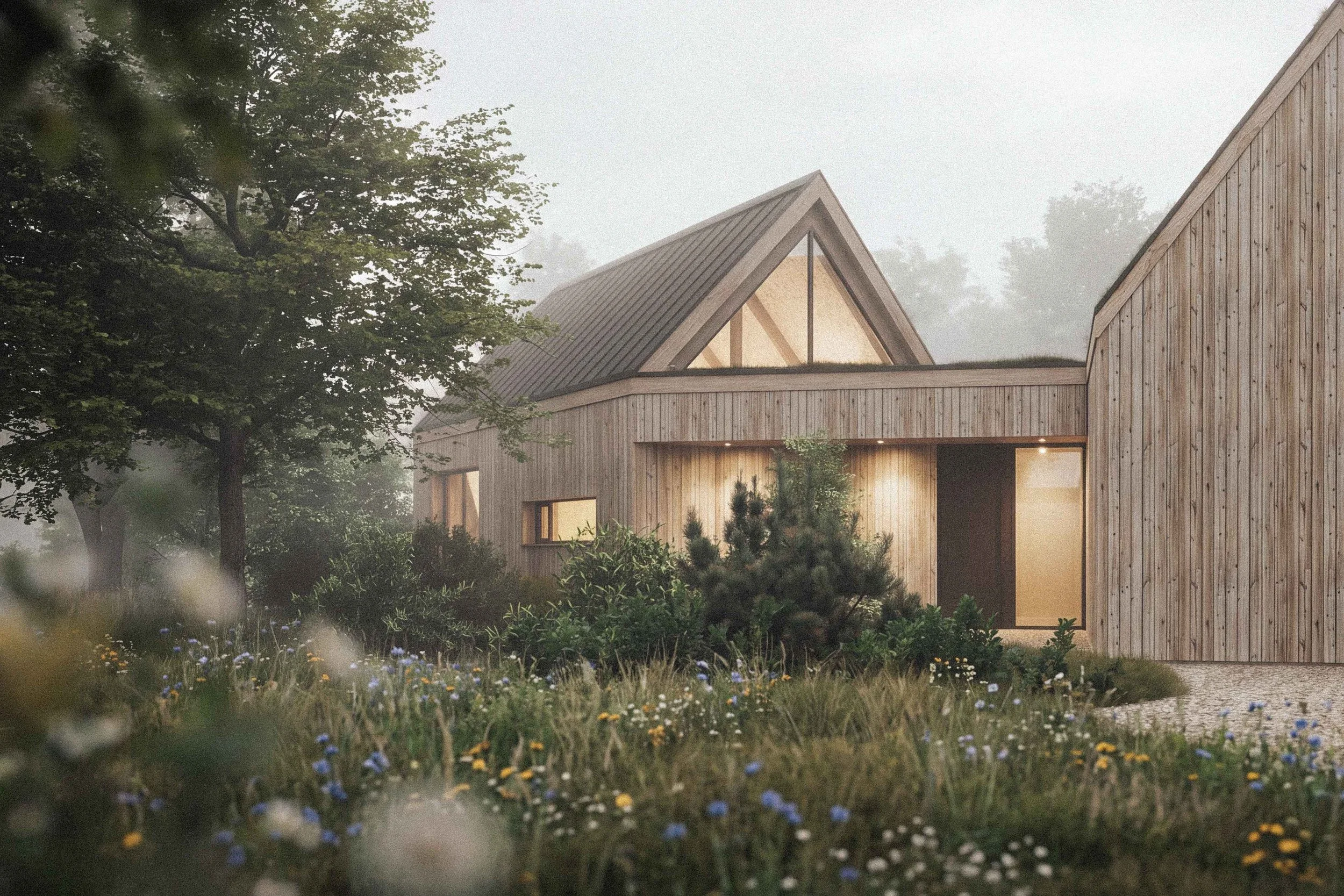 A modern house with wooden exterior walls and a steep gabled roof, surrounded by lush greenery and wildflowers, shrouded in fog.