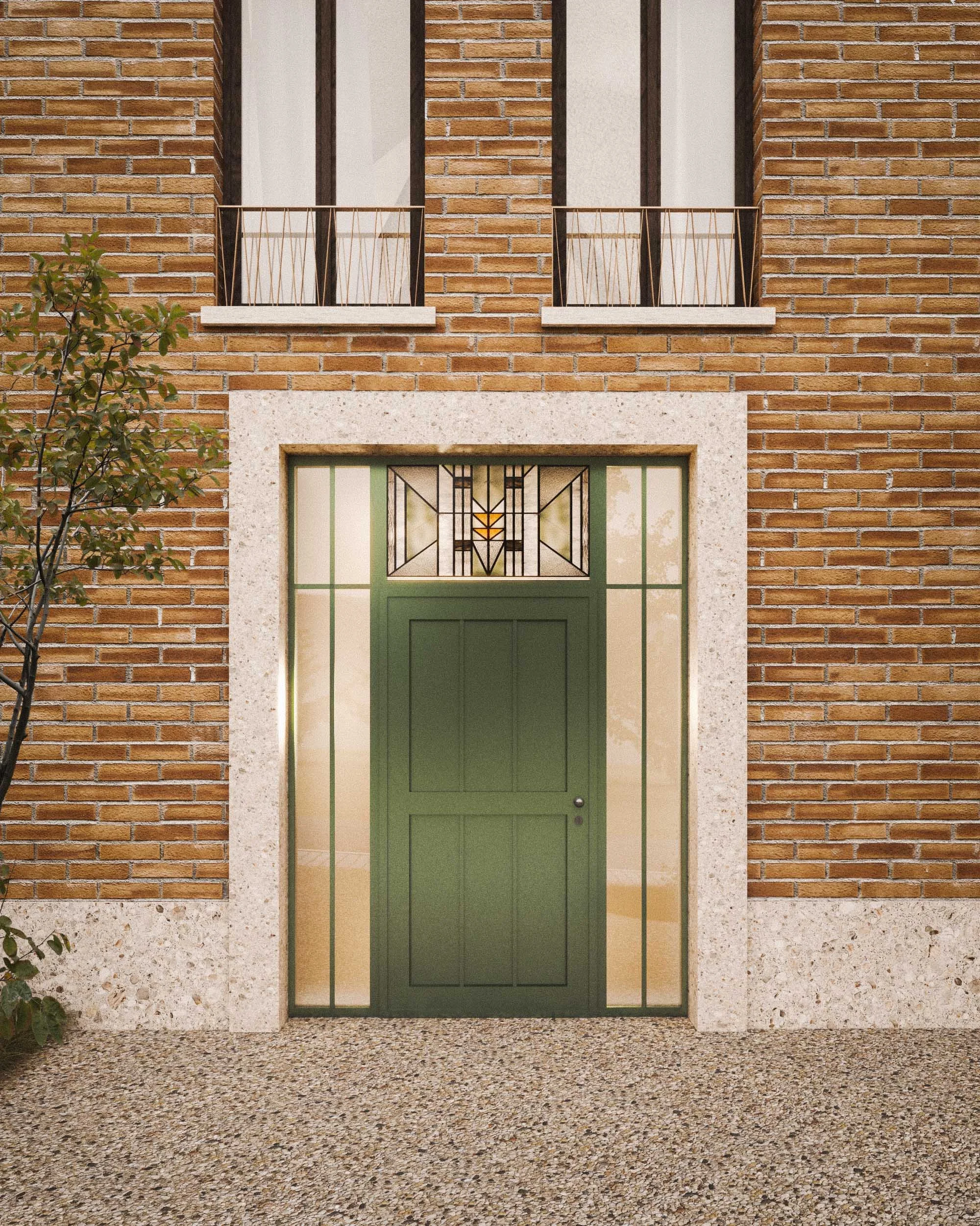 Front view of a brick building with a green door and decorative stained glass panel above it, surrounded by a textured white stone frame.