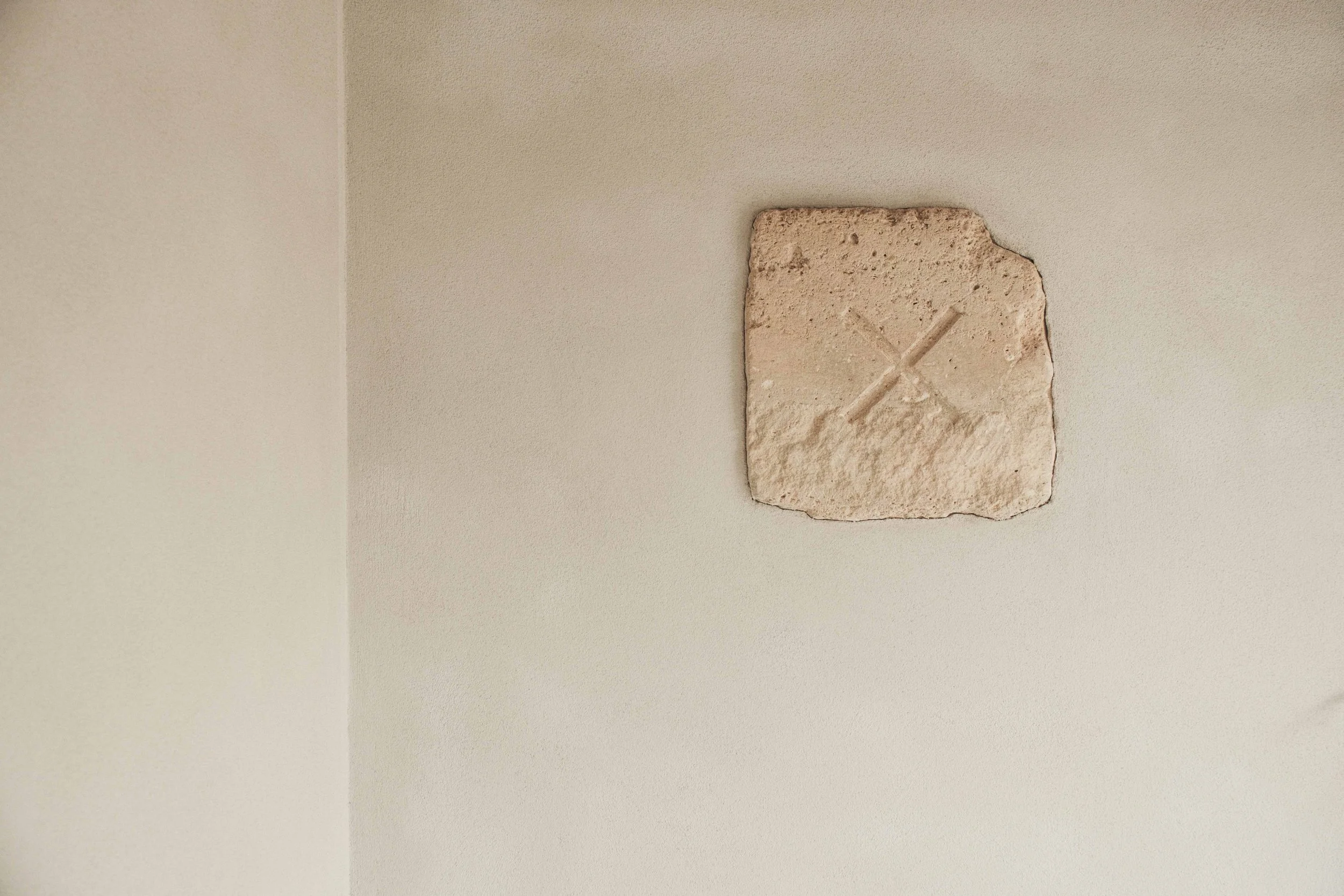 Ceiling with a damaged section of drywall and a piece of wood embedded in it.