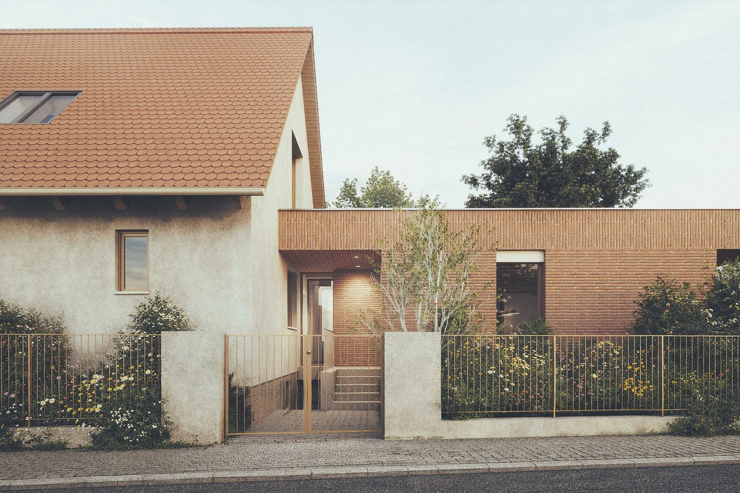 Modern house with a tan tiled roof, brick and stucco exterior, front yard with flowers and small trees, and a cobblestone sidewalk in front.