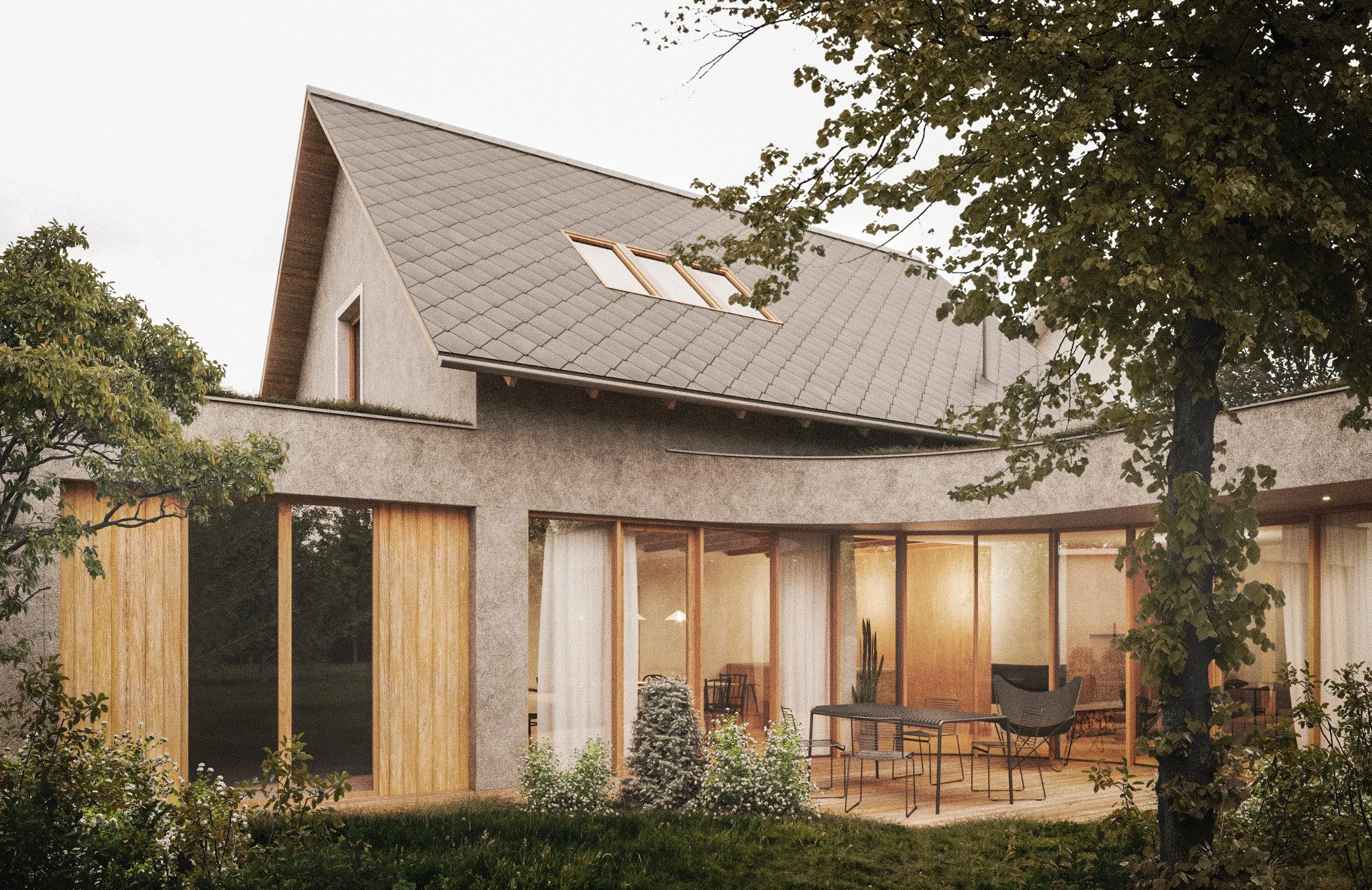 A modern house with a sloped roof featuring skylights, large glass windows, a wooden deck patio with outdoor seating, surrounded by trees