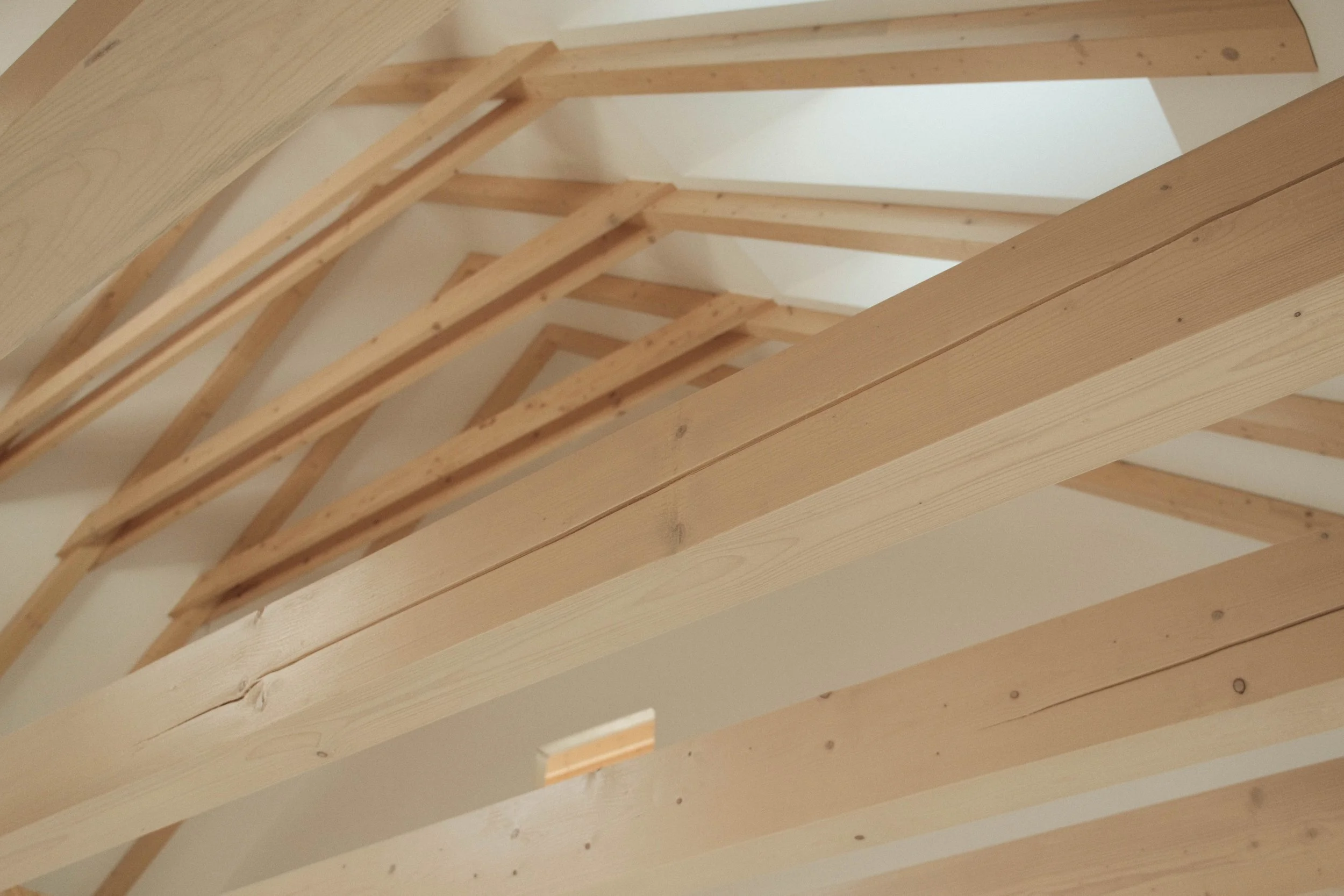 Wooden framing structure on a ceiling, showing beams and supports.