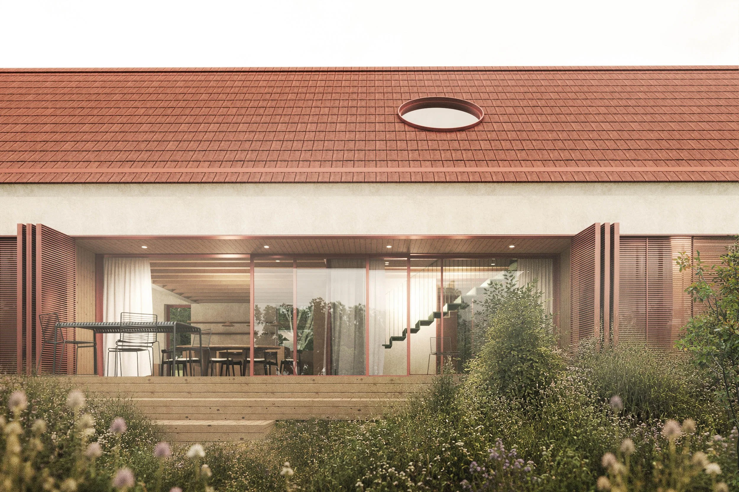 Backyard view featuring a modern house with a large glass sliding door, an outdoor dining area with chairs and a table, surrounded by greenery and flowering plants, and a red-tiled roof with a circular skylight.